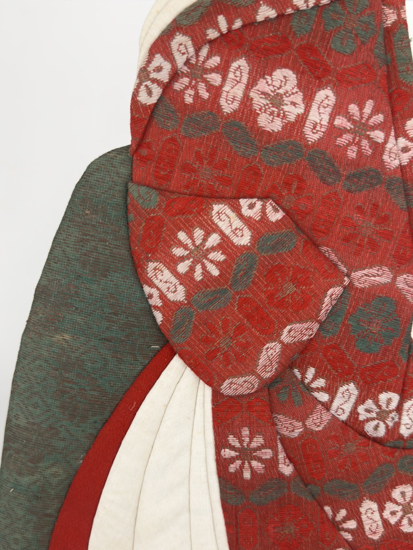 Okiyage japonais représentant une femme en kimono vert à motifs floraux dorés, coiffée de kanzashi, réalisé en tissus traditionnels, détail sur le kimono