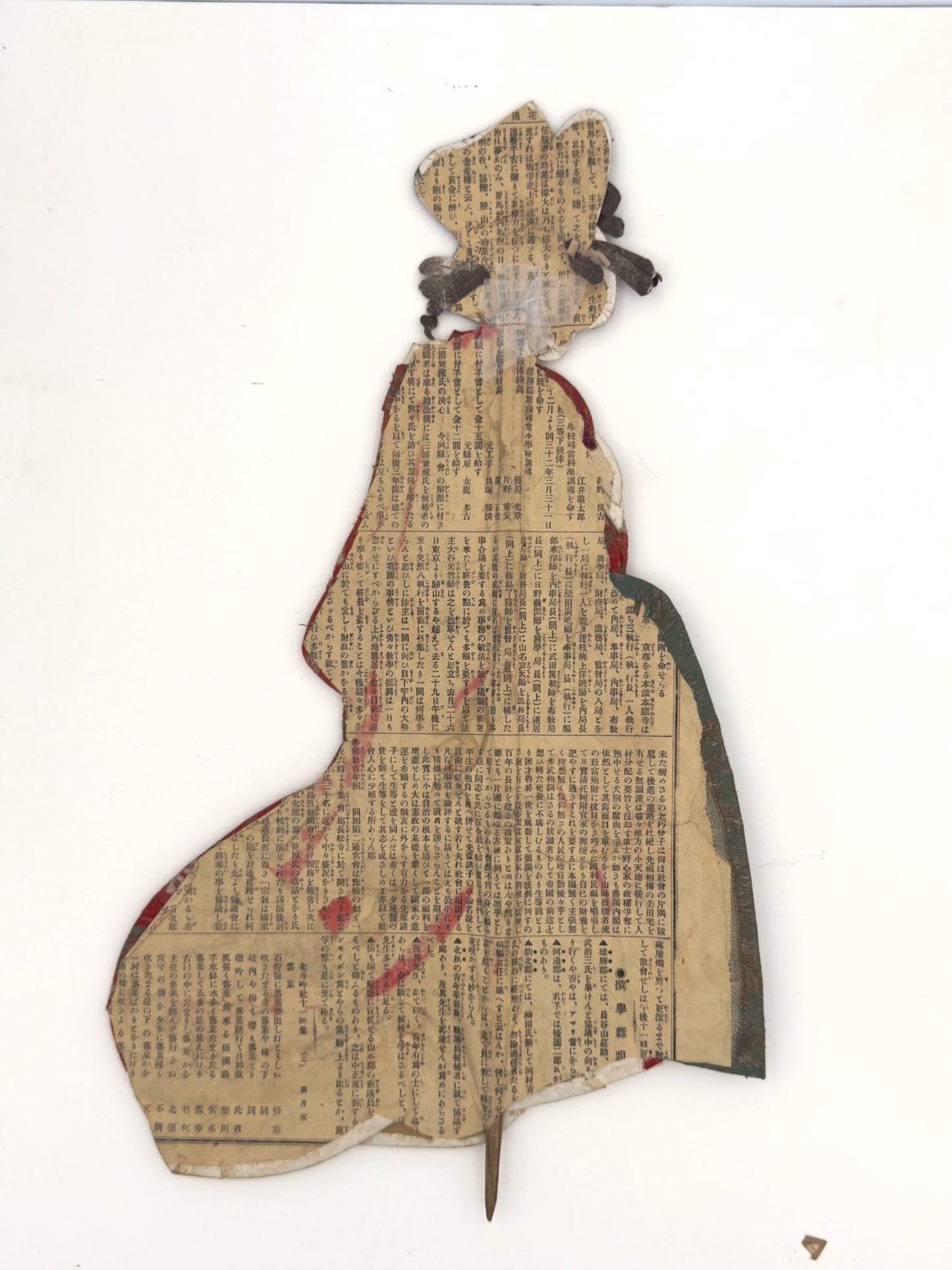 Okiyage japonais représentant une femme en kimono vert à motifs floraux dorés, coiffée de kanzashi, réalisé en tissus traditionnels, le verso avec papier journal ancien