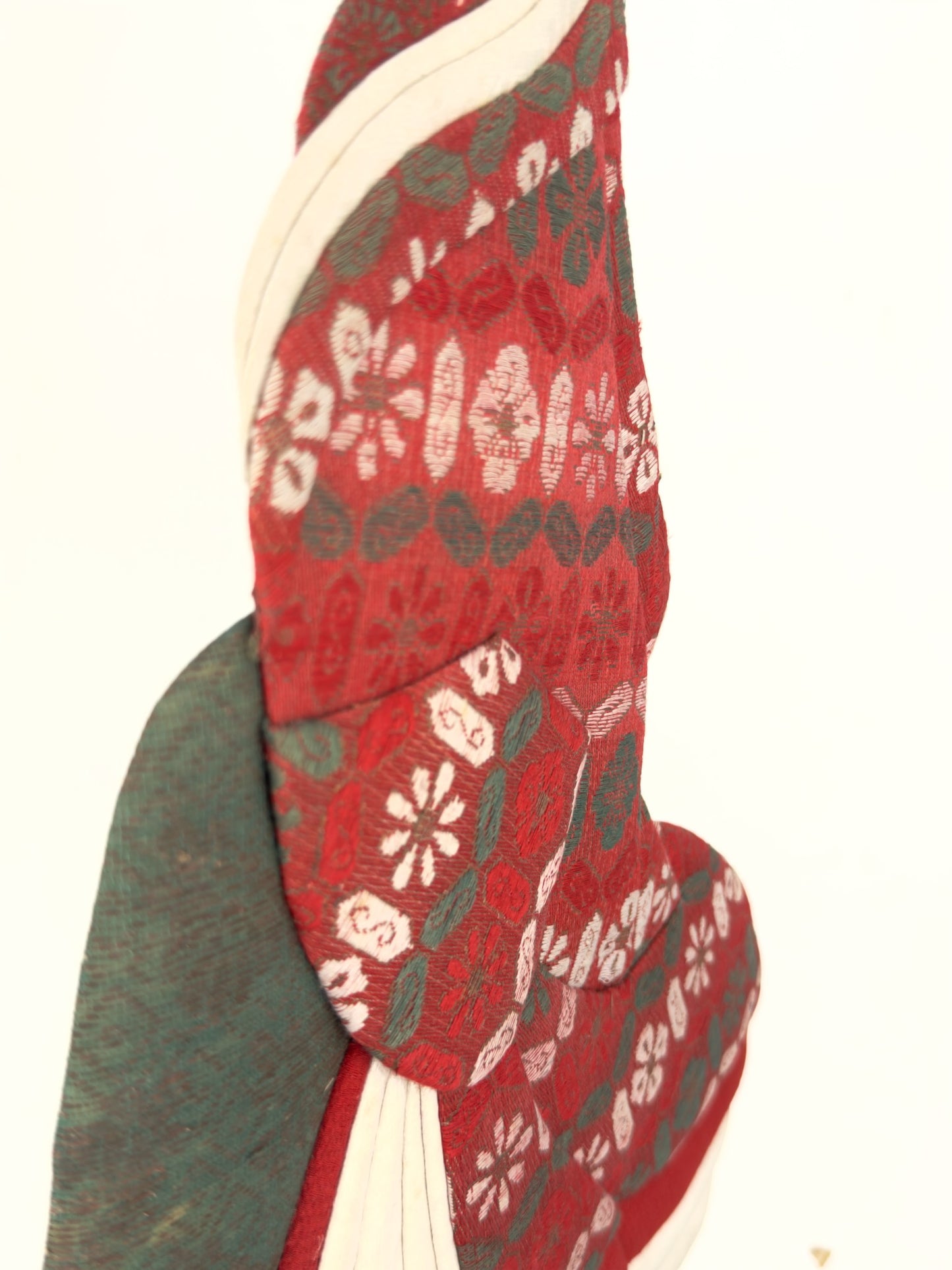 Okiyage japonais représentant une femme en kimono vert à motifs floraux dorés, coiffée de kanzashi, réalisé en tissus traditionnels, vu de profil