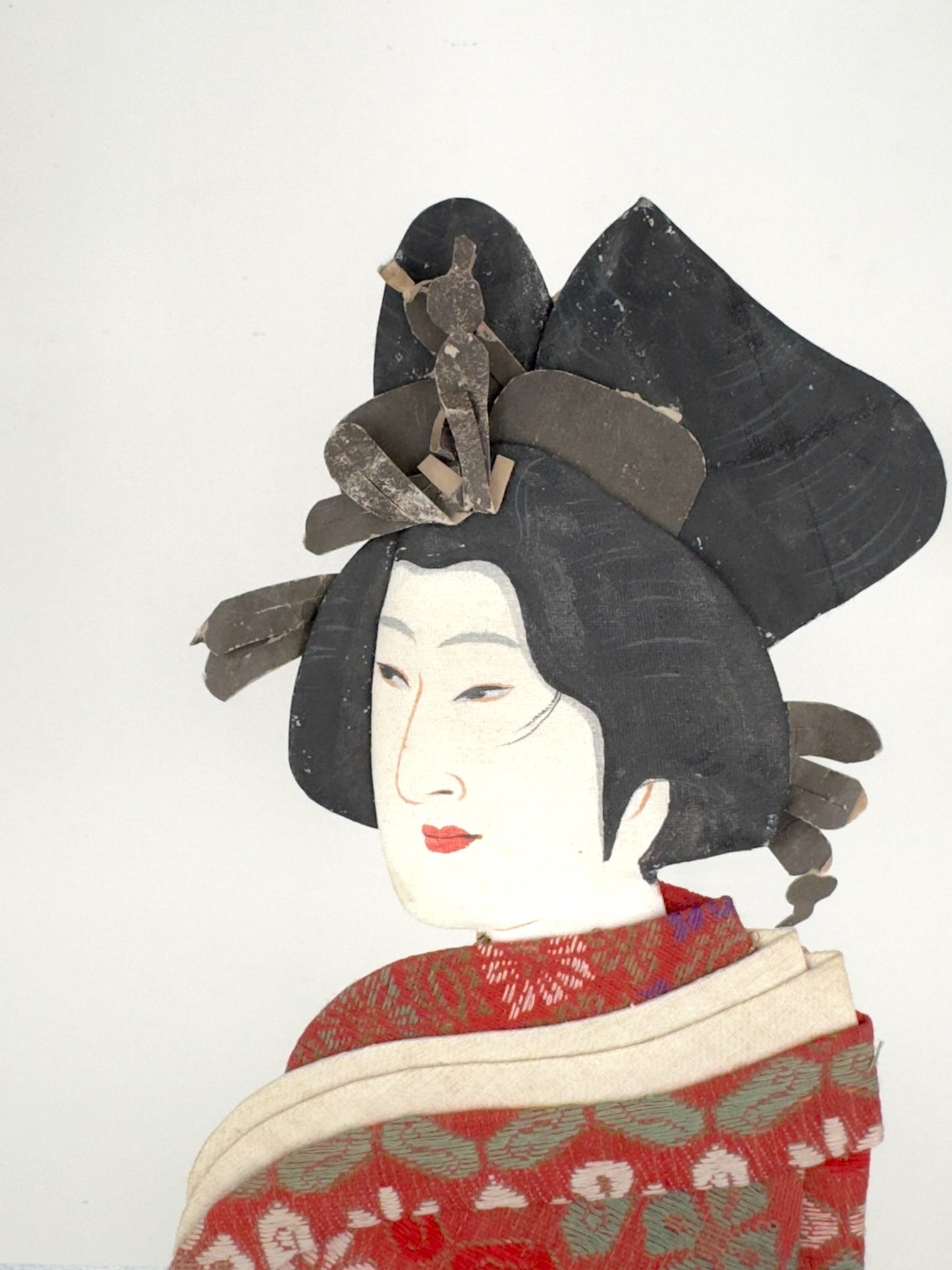 Okiyage japonais représentant une femme en kimono vert à motifs floraux dorés, coiffée de kanzashi, réalisé en tissus traditionnels, gros plan sur le visage