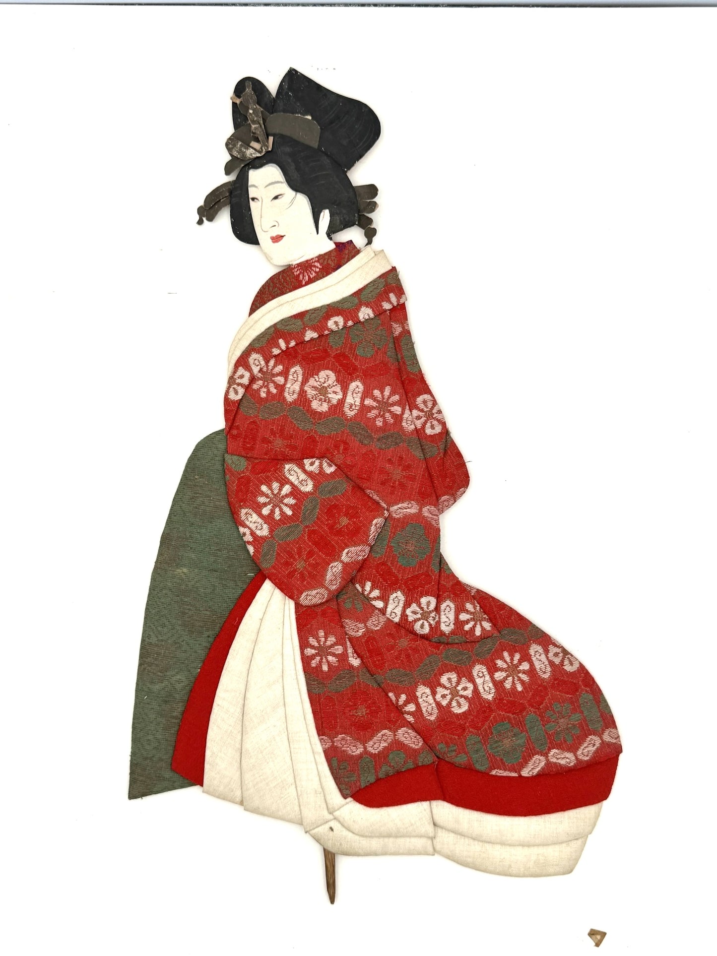 Okiyage japonais représentant une femme en kimono vert à motifs floraux dorés, coiffée de kanzashi, réalisé en tissus traditionnels et papier journal ancien