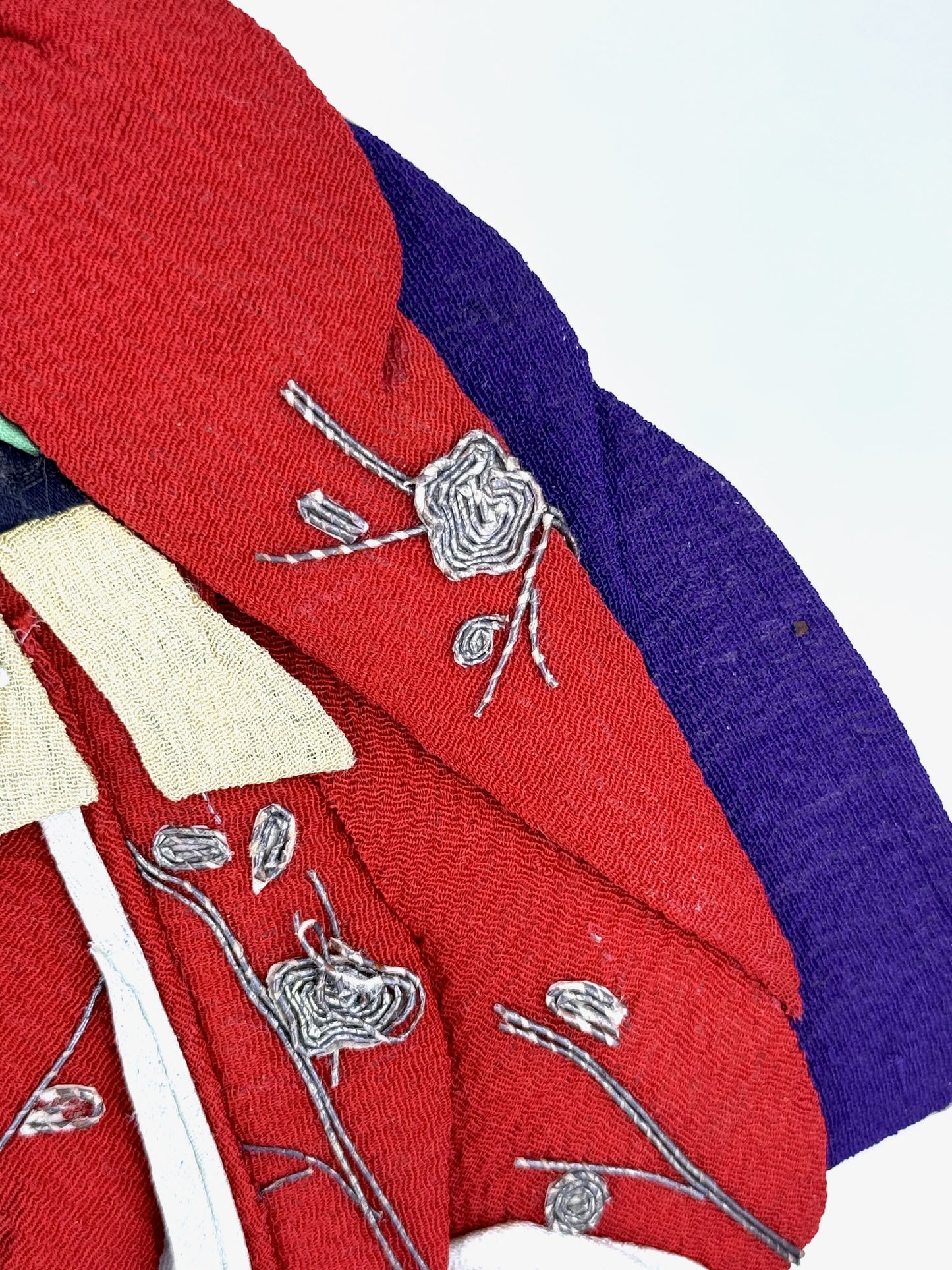 Okiyage japonais représentant une femme en kimono rouge brodé tenant un tambour tsuzumi, réalisée en tissu ancien avec coiffure et accessoires traditionnels, gros plan sur le kimono