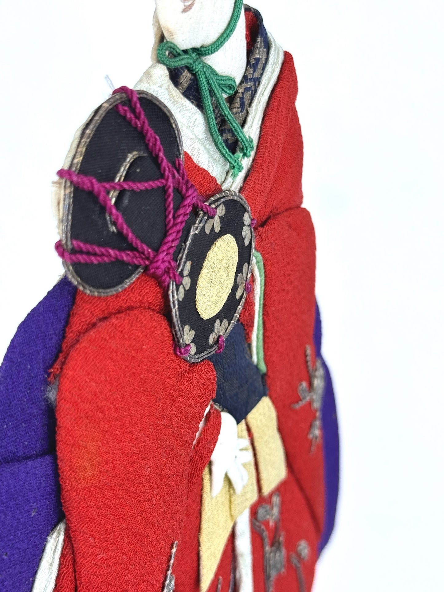 Okiyage japonais représentant une femme en kimono rouge brodé tenant un tambour tsuzumi, réalisée en tissu ancien avec coiffure et accessoires traditionnels, vu de profil