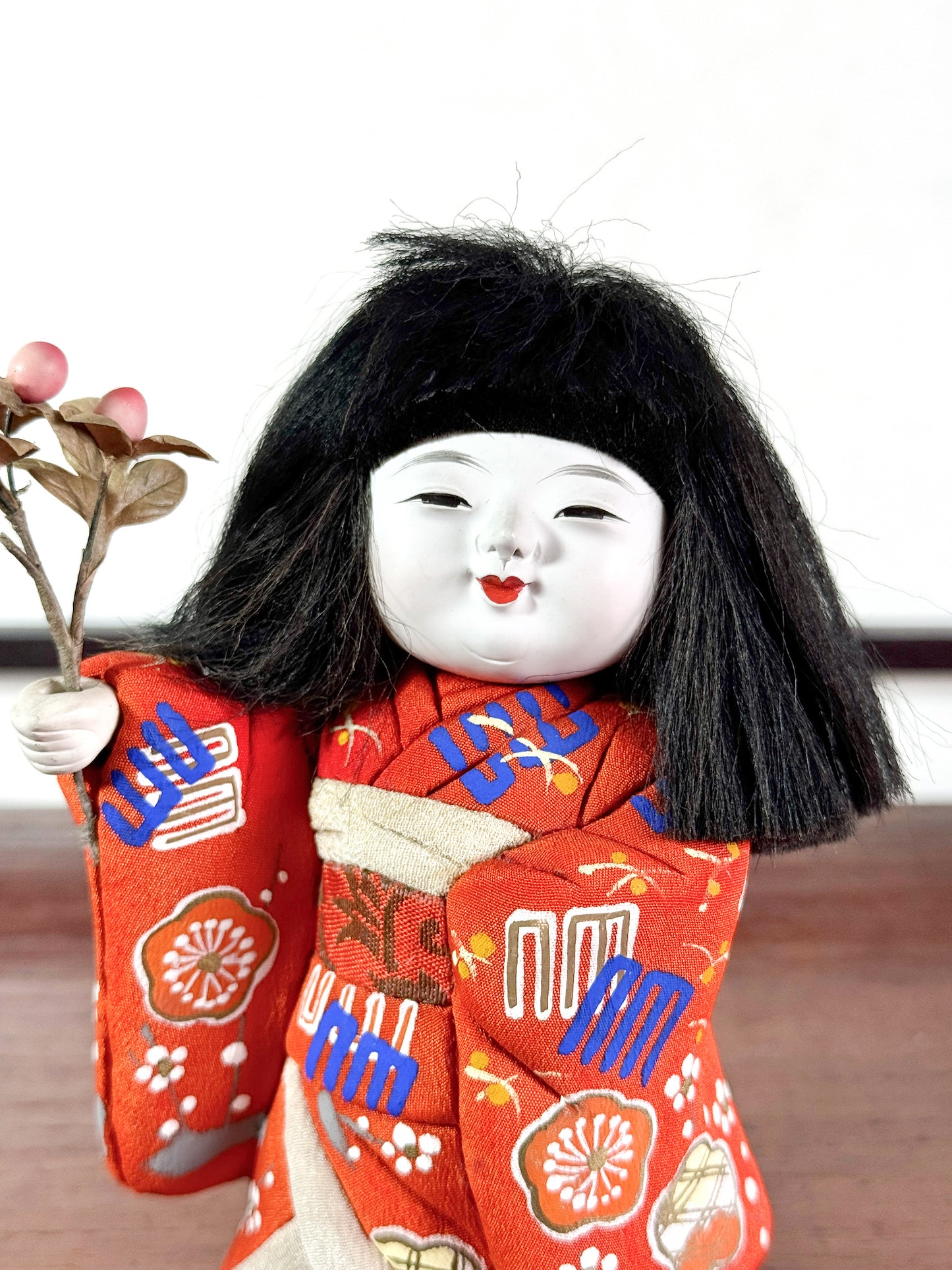 poupée japonaise en kimono rouge avec bouquet de fleurs, gros plan sur le visage