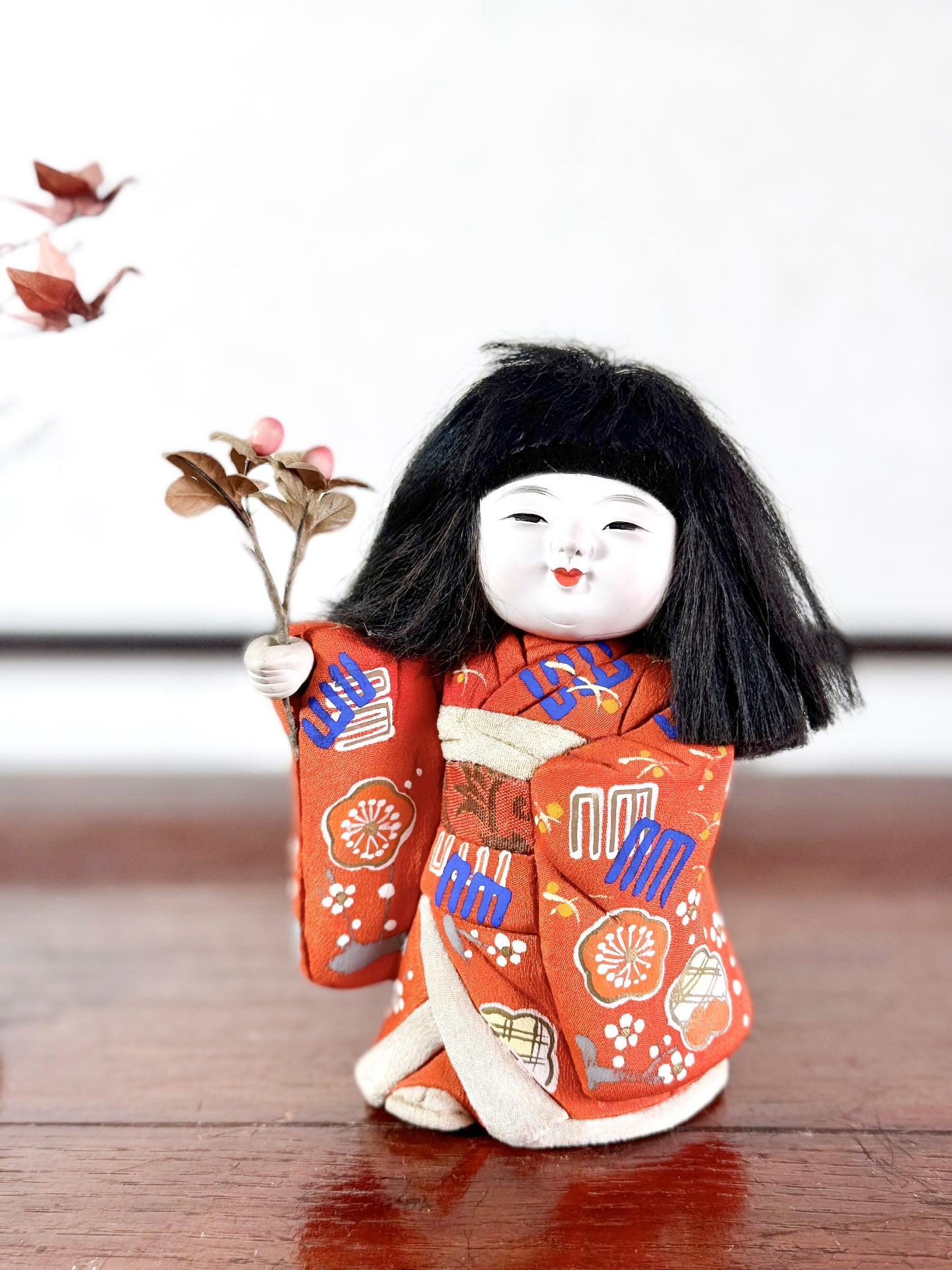 poupée japonaise en kimono rouge avec bouquet de fleurs