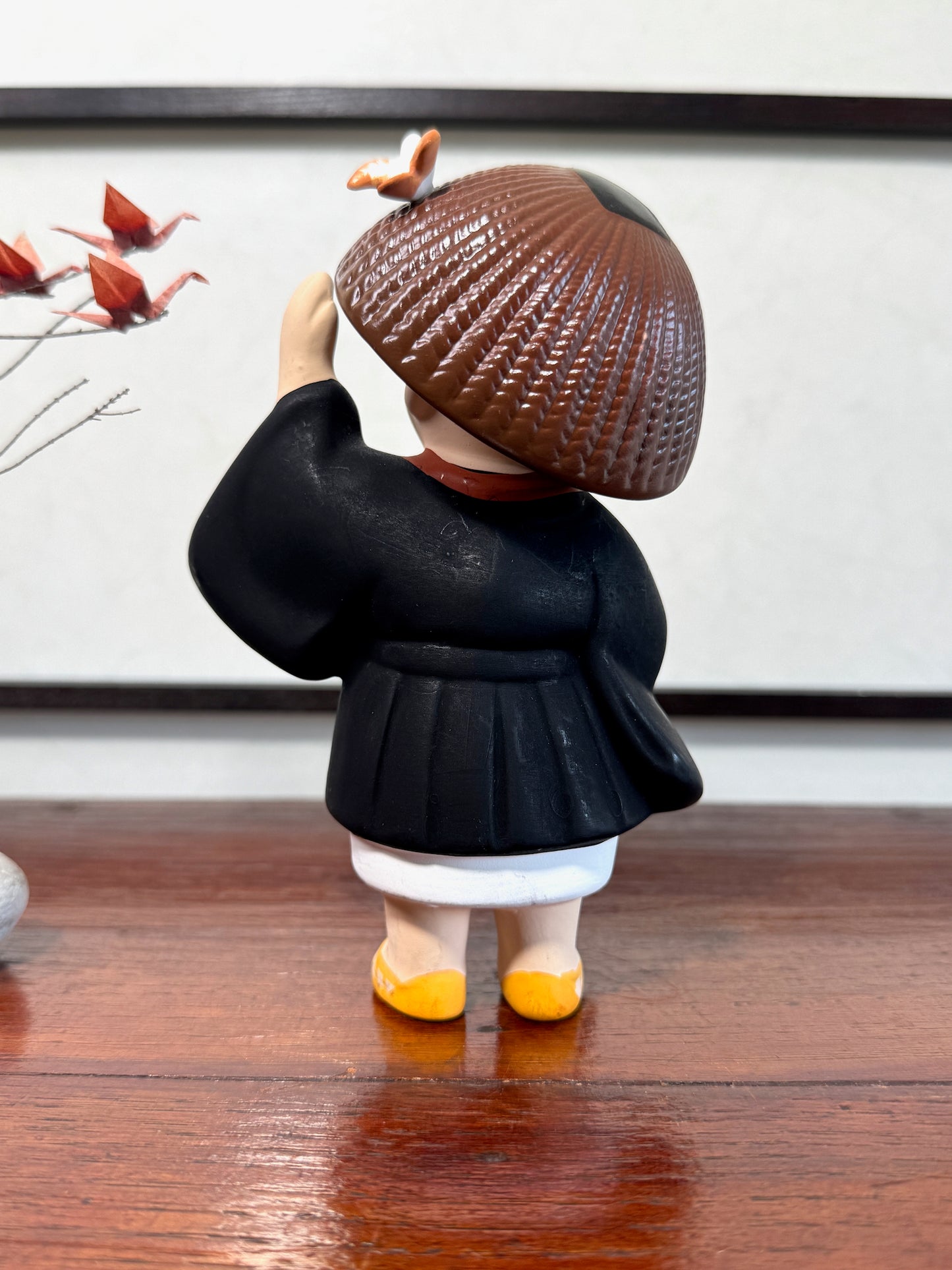 statuette enfant pèlerin en céramique japonaise avec chapeau et bâton, vu de dos