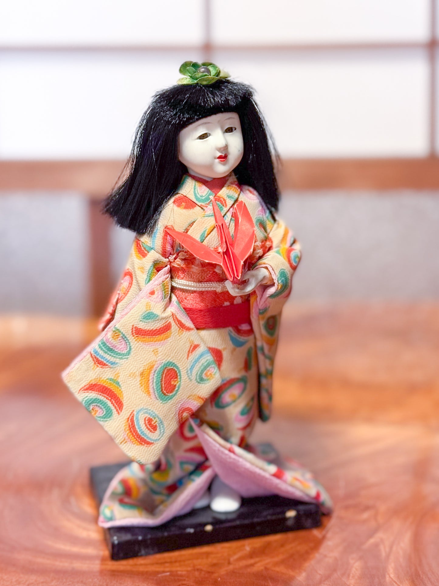 poupée japonaise Ichimatsu en kimono avec grue rouge en origami, vu du profil droit