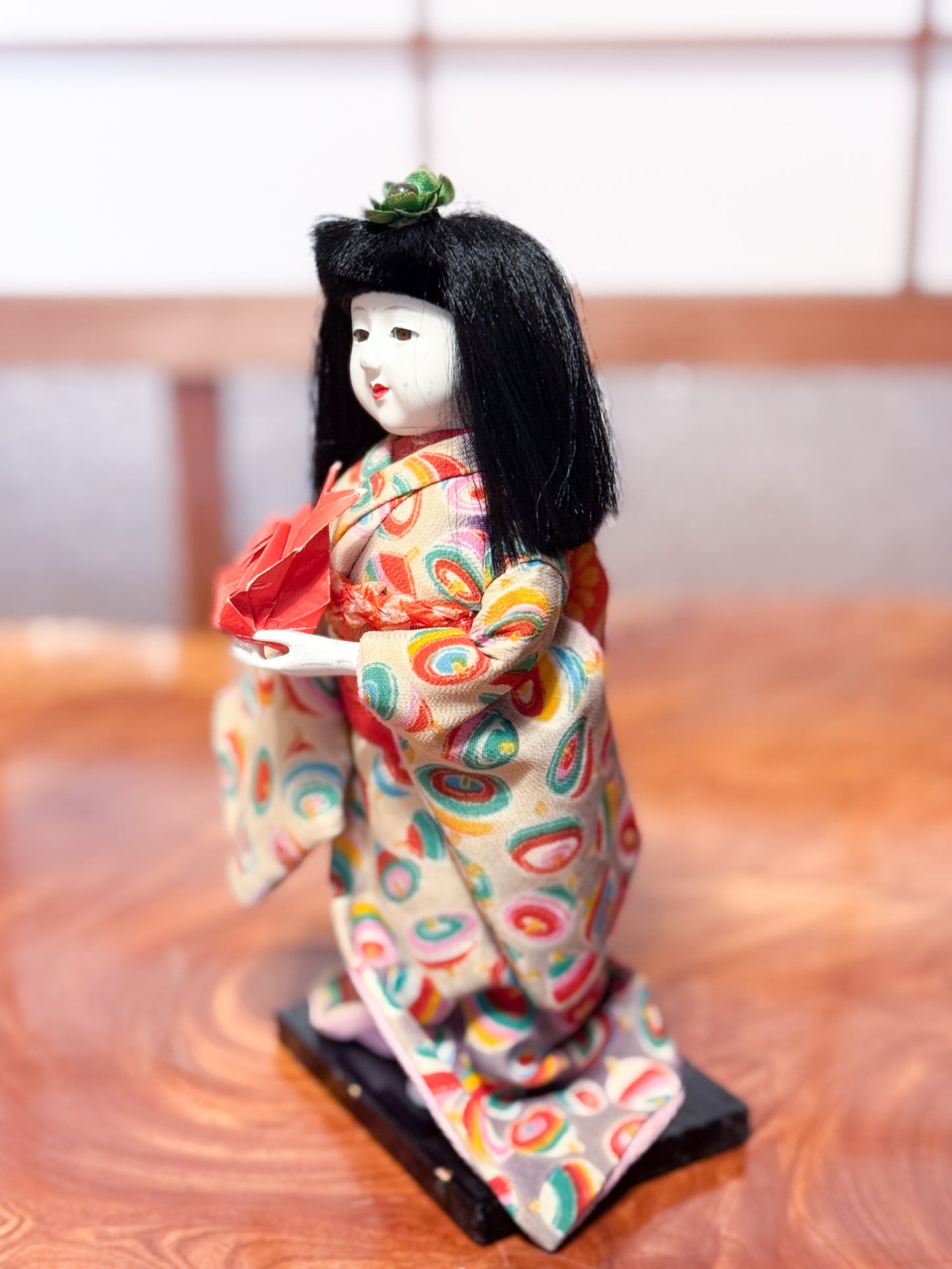 poupée japonaise Ichimatsu en kimono avec grue rouge en origami, vu du profil gauche