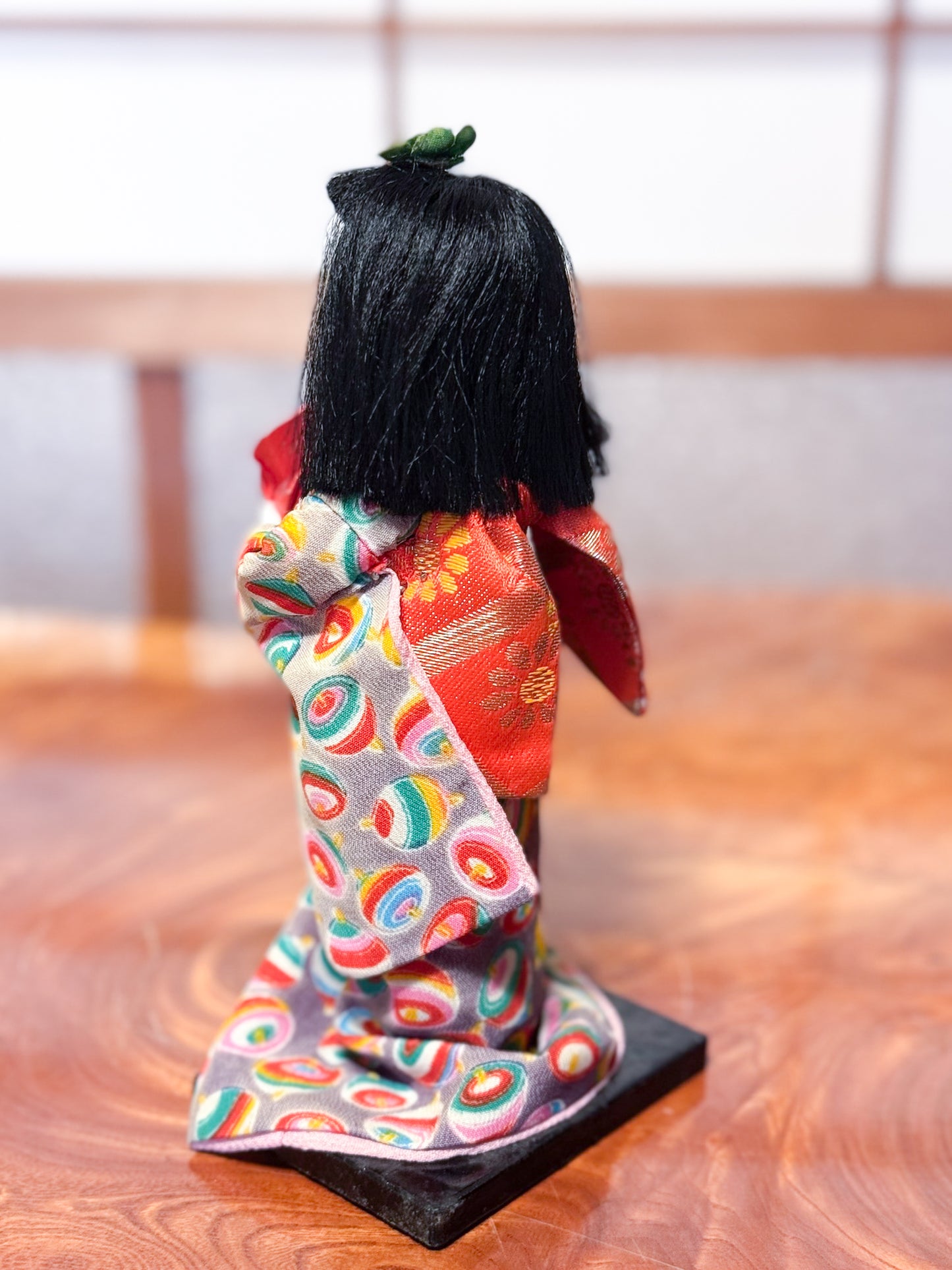 poupée japonaise Ichimatsu en kimono avec grue rouge en origami, vu de dos tissu kimono motif toupie