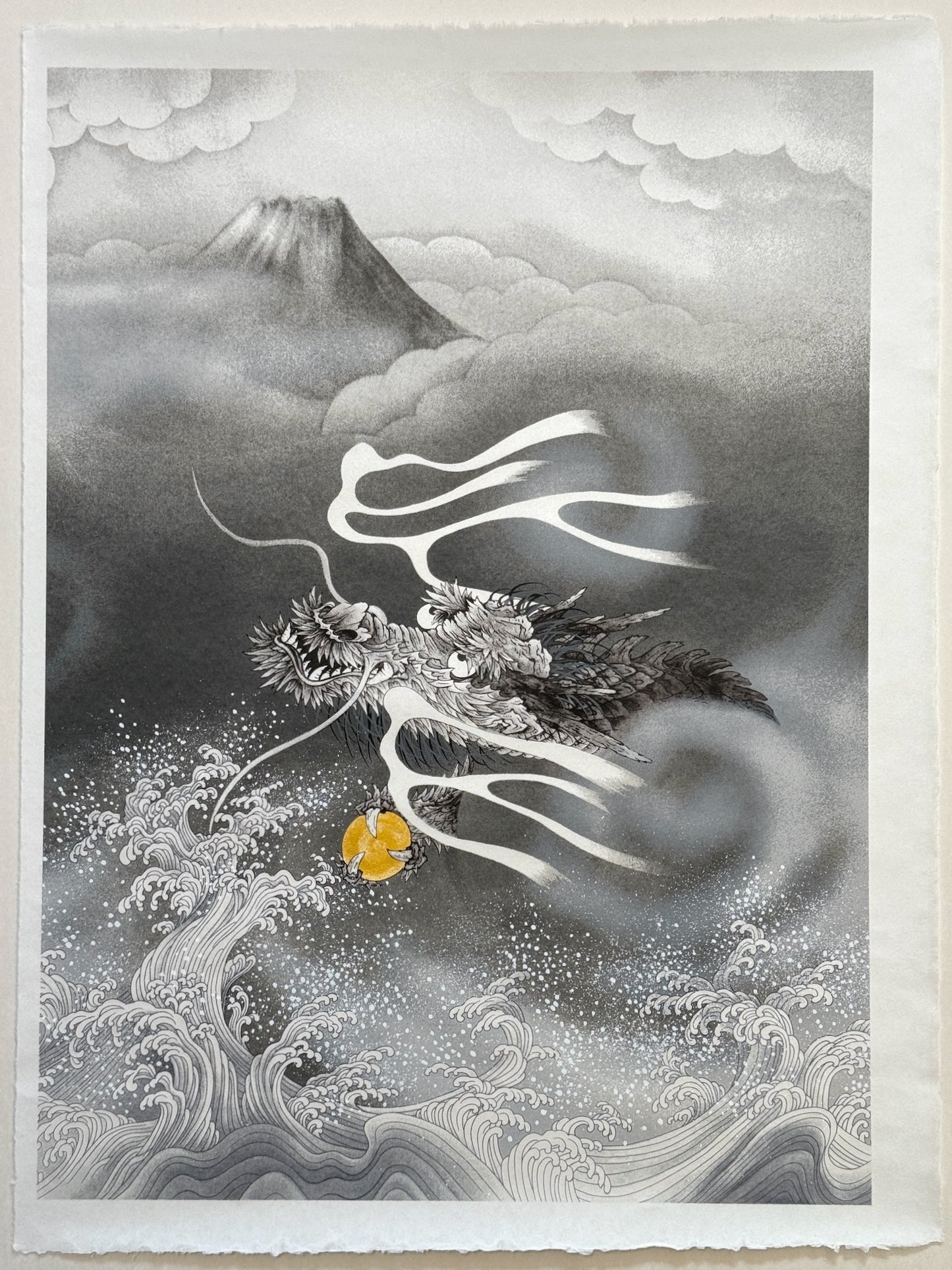 Sérigraphie Japonaise d'un Dragon et du Mont Fuji. Jaillit de la brume au dessus des vagues déchainées blanches et grises, nuages épais autour de la montagne.