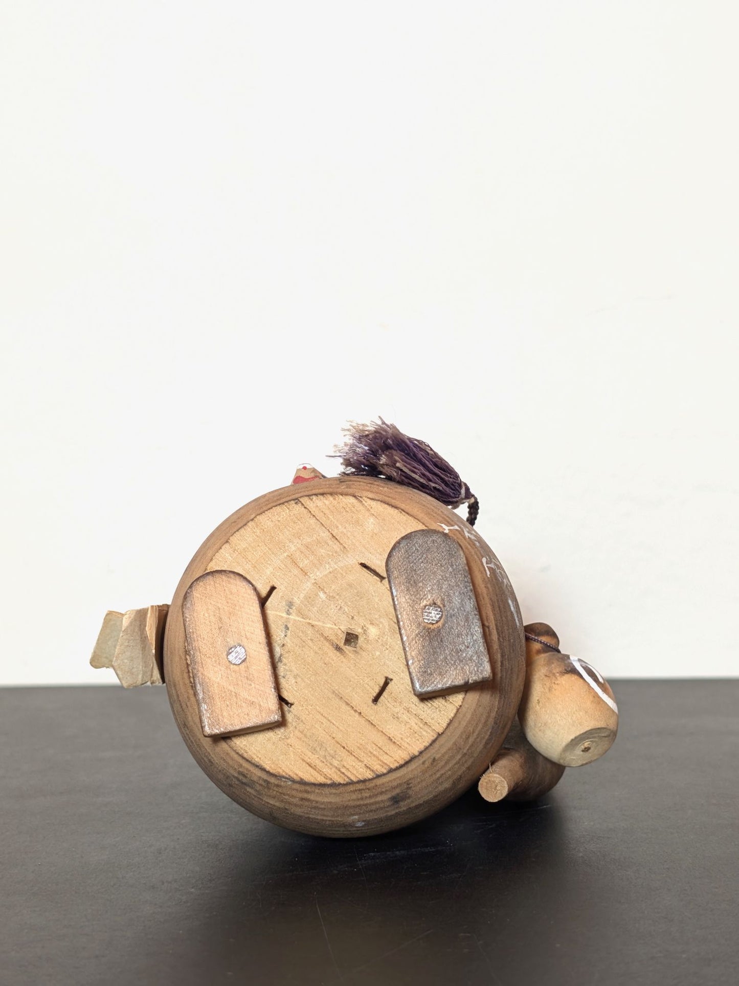 Tanuki en bois avec chapeau, bouteille de saké et bébé tanuki, sculpture japonaise artisanale symbolisant chance et prospérité, vu de dessous