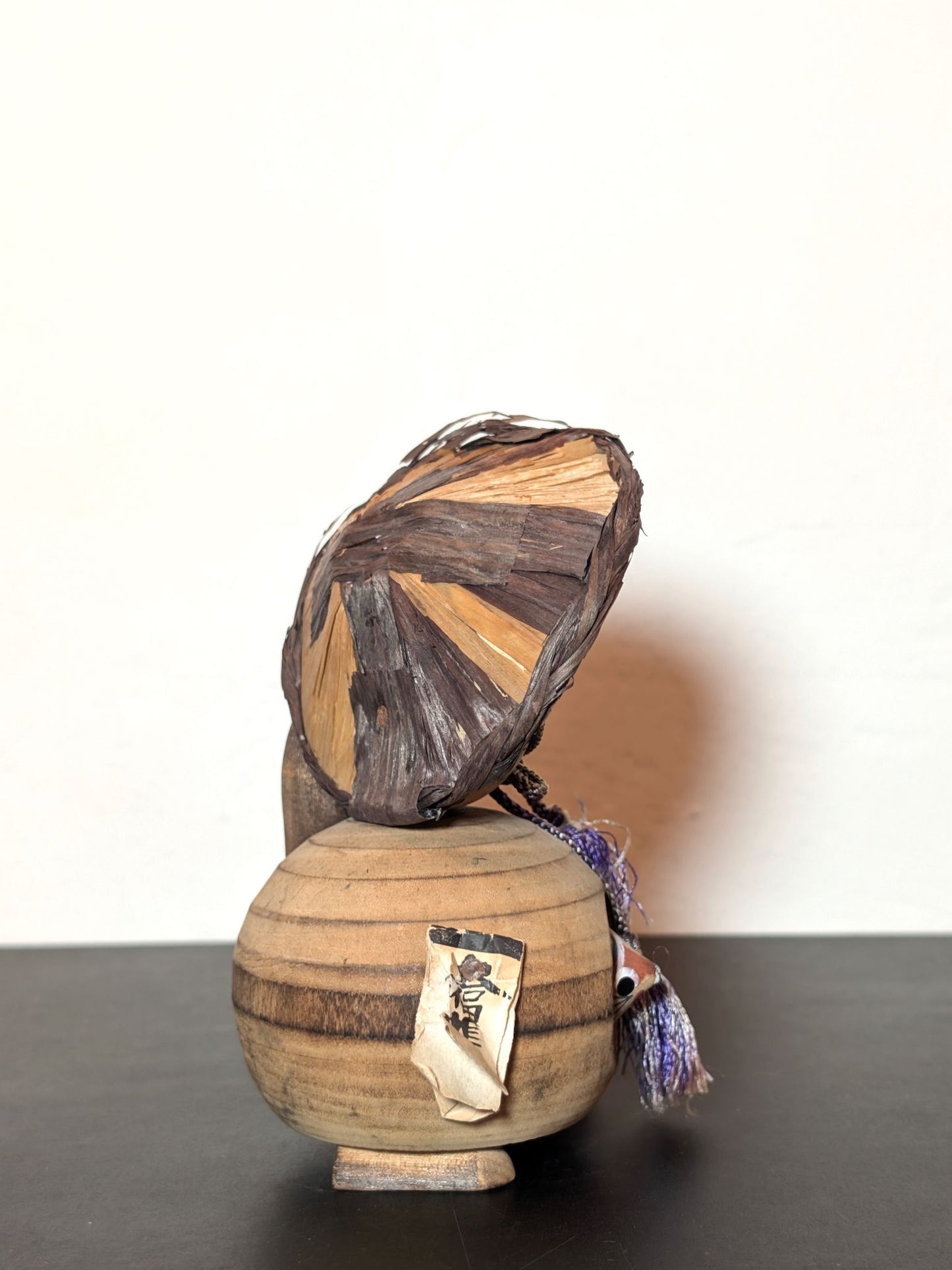 Tanuki en bois avec chapeau, bouteille de saké et bébé tanuki, sculpture japonaise artisanale symbolisant chance et prospérité, profil droit