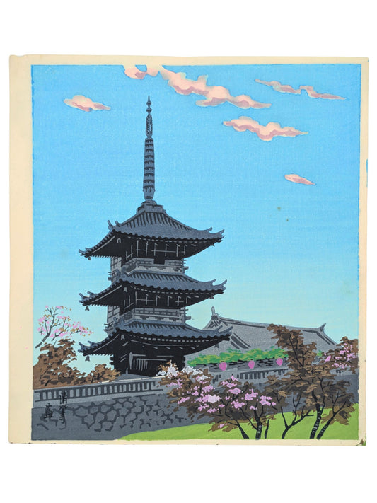 estampe japonaise de tokuriki de la pagode du kiyomizu dera au printemps dans un ciel bleu aux nuages rosés. Les toits traditionnels gris contraste avec les couleurs pastel.