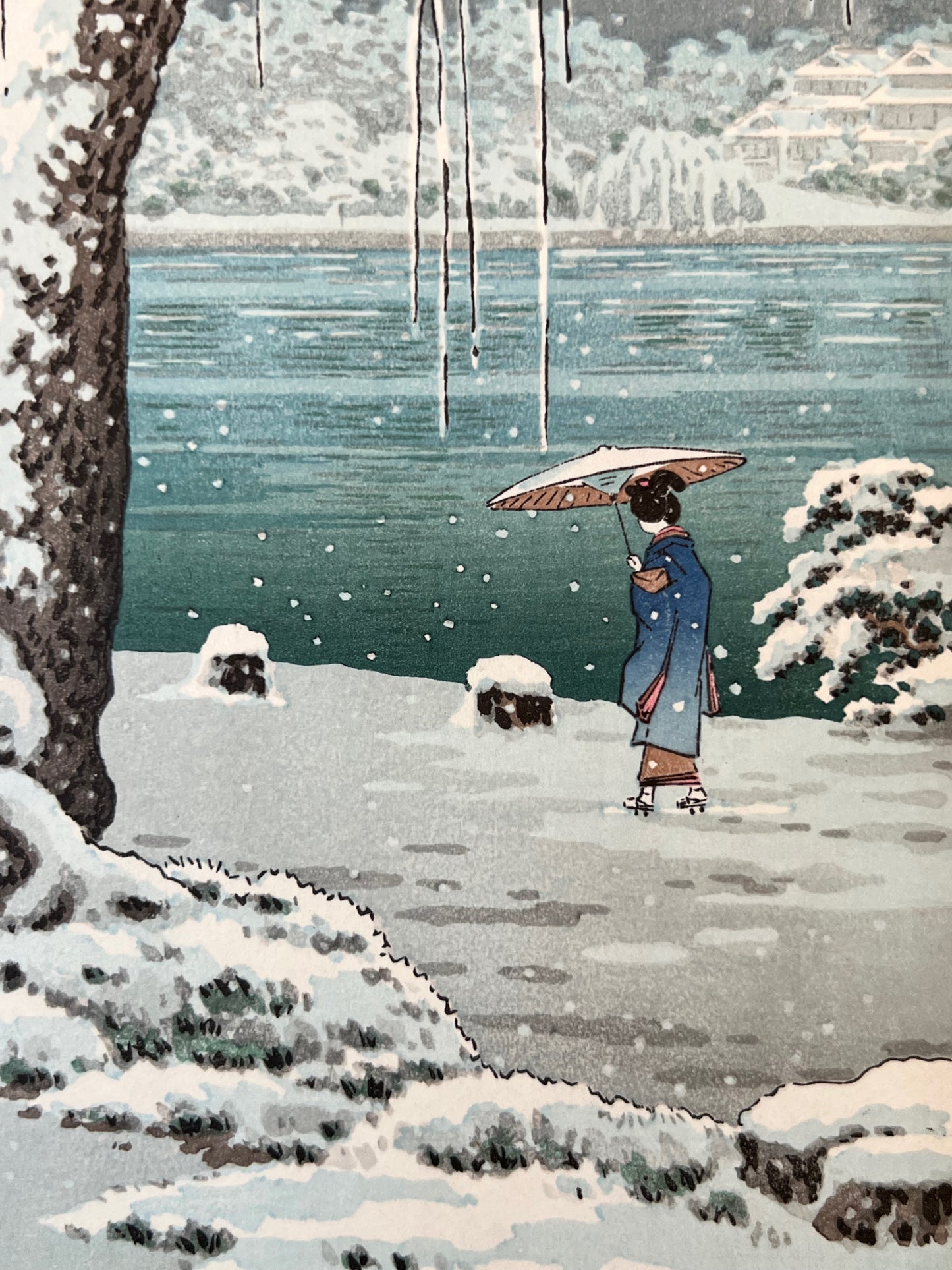 estampe japonaise de koitsu paysage de neige etang et arbre gele, gros plan sur femme sous un parapluie marchant sous la neige au bord de l'étang