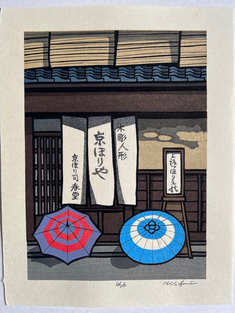 estampe japonaise de nishijima parapluie colorés ouvert devant une boutique en bois