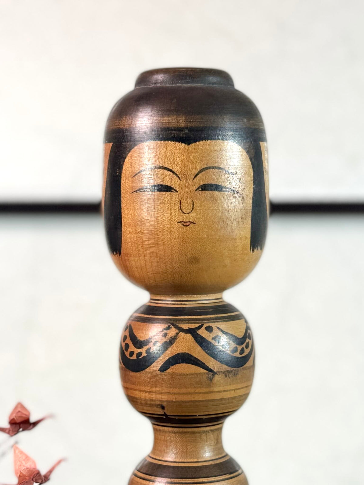 kokeshi poupée japonaise en bois motif pivoine en noir et blanc de Sato Zenji, gros plan du visage