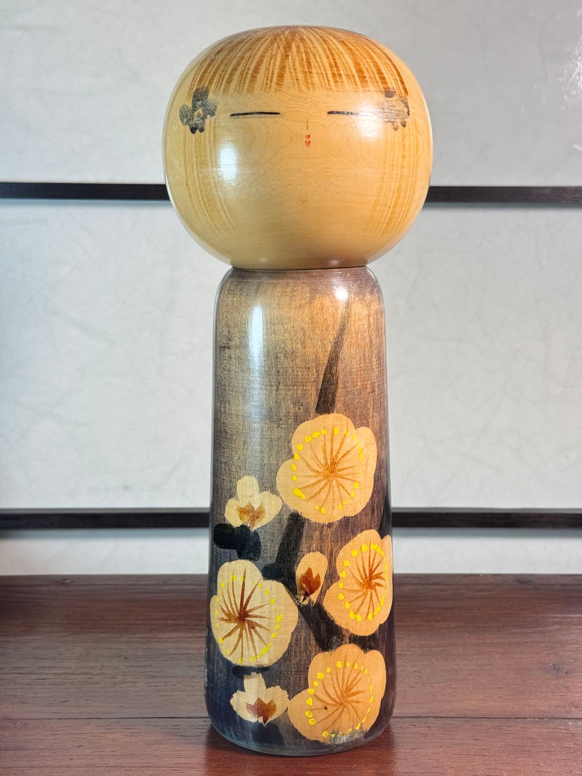 kokeshi, poupée japonaise en bois de Usuki Hakuho bleue avec motif branche de prunier en fleur, vu de face