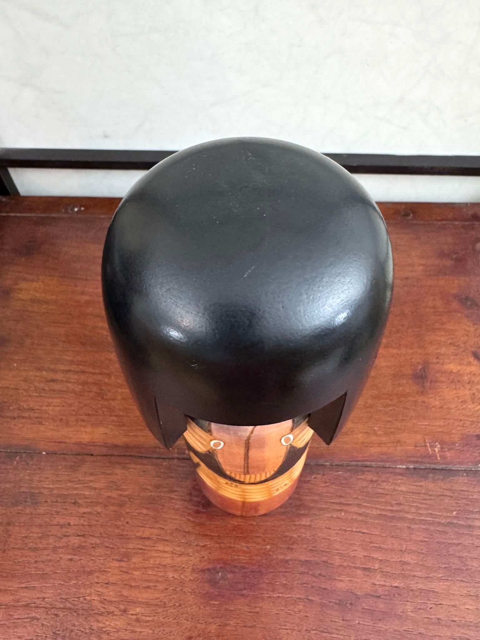 Kokeshi vintage Shinonome de Kisaku avec kimono sculpté en relief et coiffure noire, vu de dessus