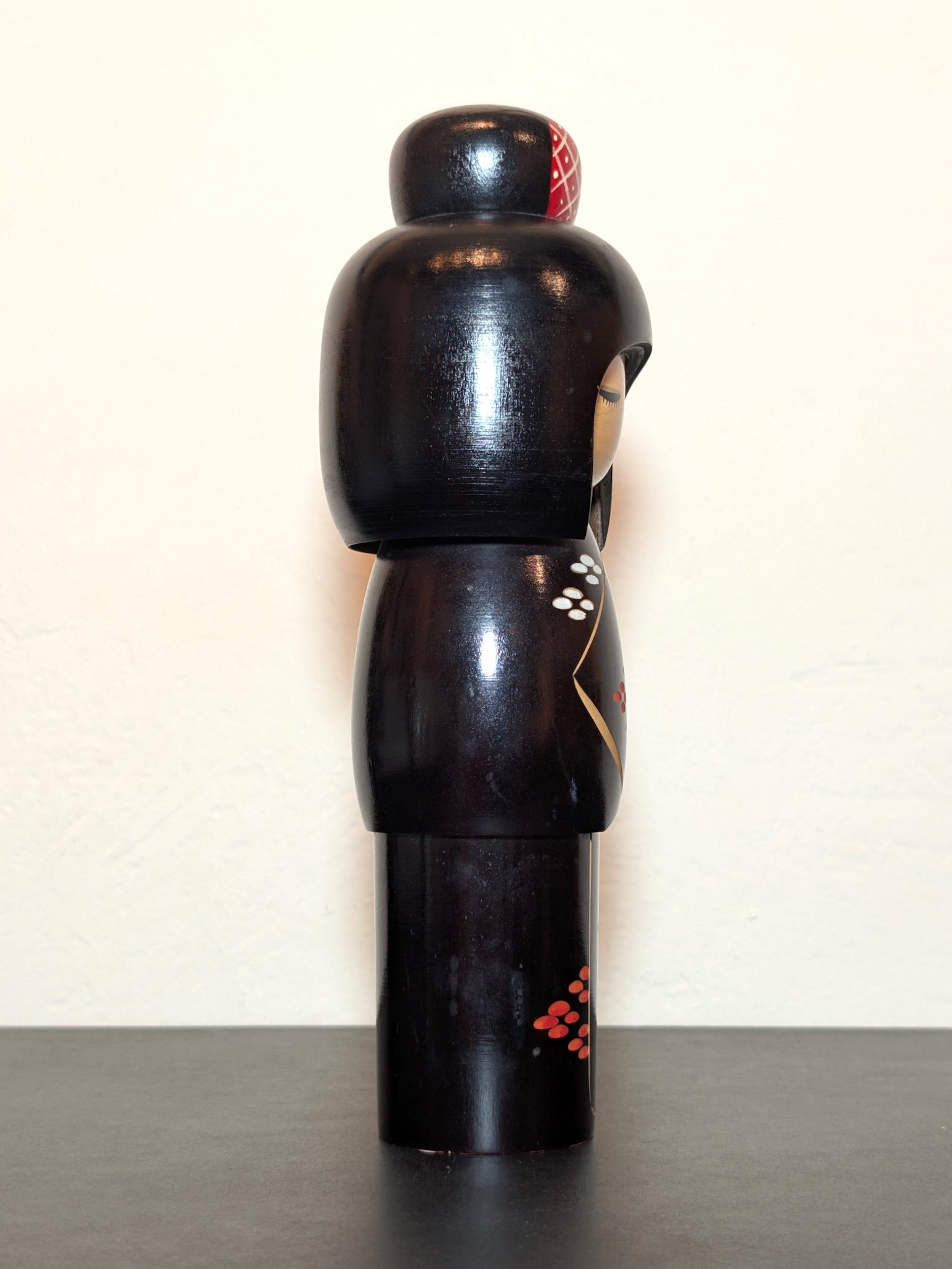 kokeshi de Kunio Miyagawa, kimono noir avec fleurs de cerisier rouges et blanches, profil droit