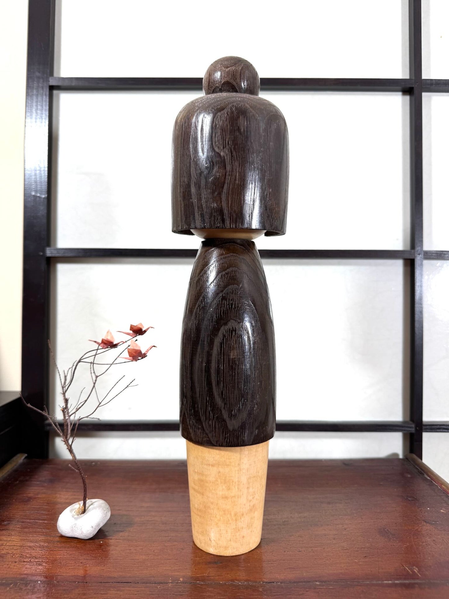 Grande kokeshi Usaburō Koigokoro en bois sombre avec fleurs de prunier rouges et blanches, vu de dos