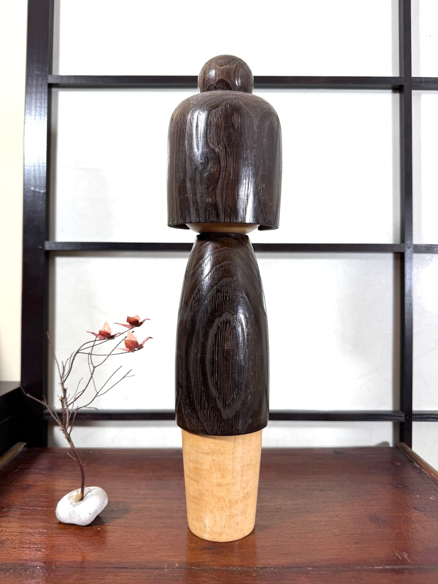 Grande kokeshi Usaburō Koigokoro en bois sombre avec fleurs de prunier rouges et blanches, vu de dos