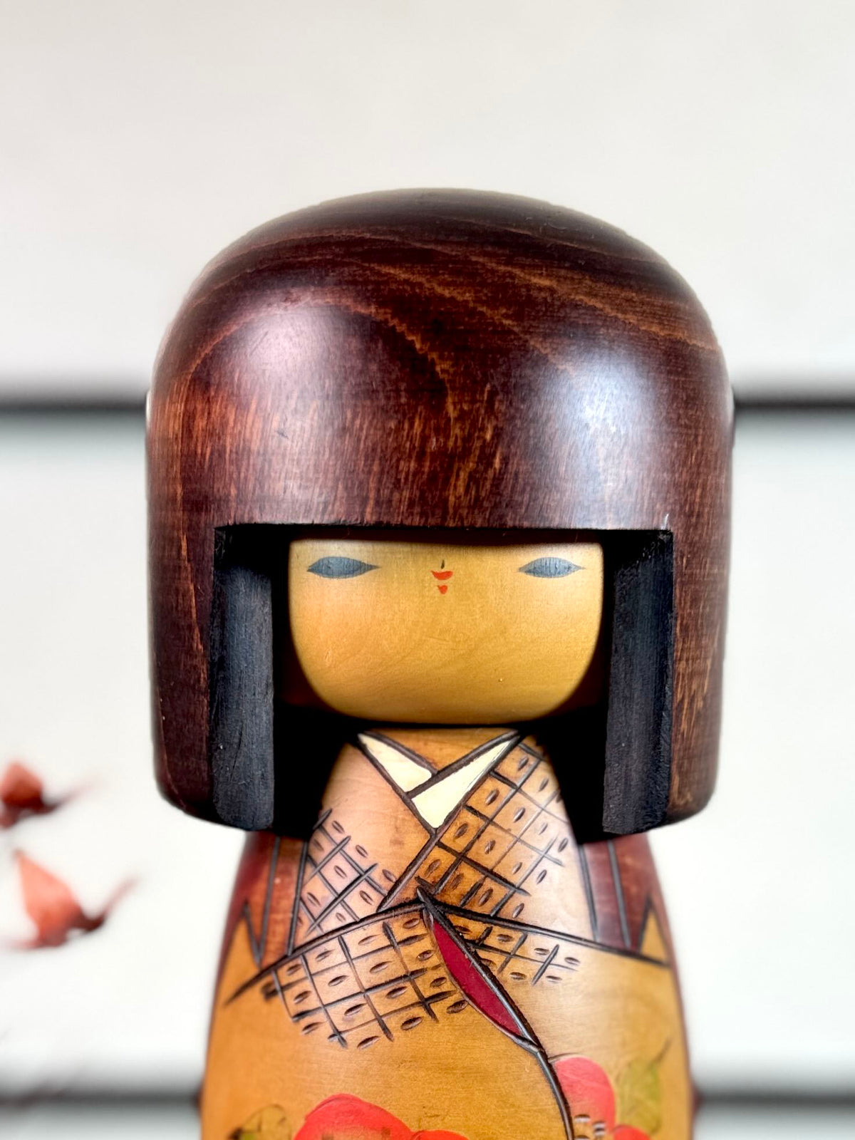 Kokeshi vintage Usaburō de 25 cm ornée de camélias rouges, gros plan sur le visage
