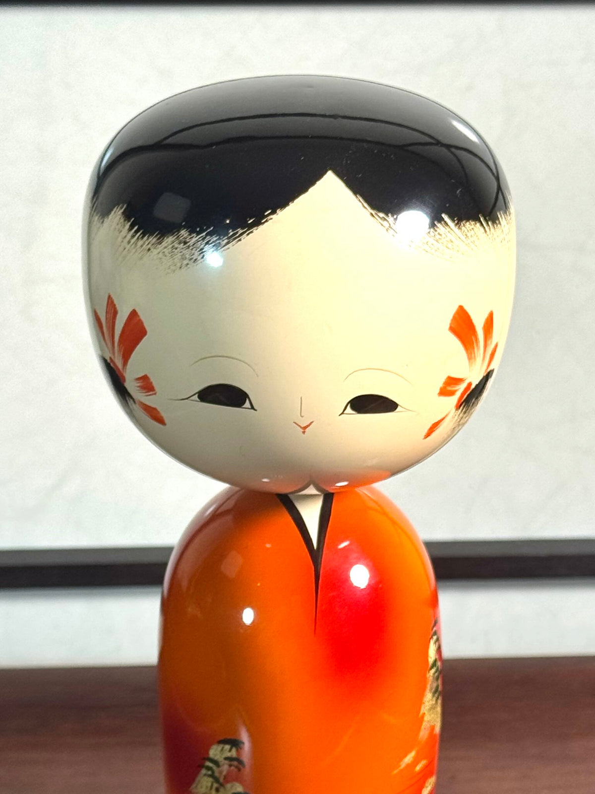 Kokeshi vintage laquée orange de Wajima à paysage japonais doré, gros plan sur le visage