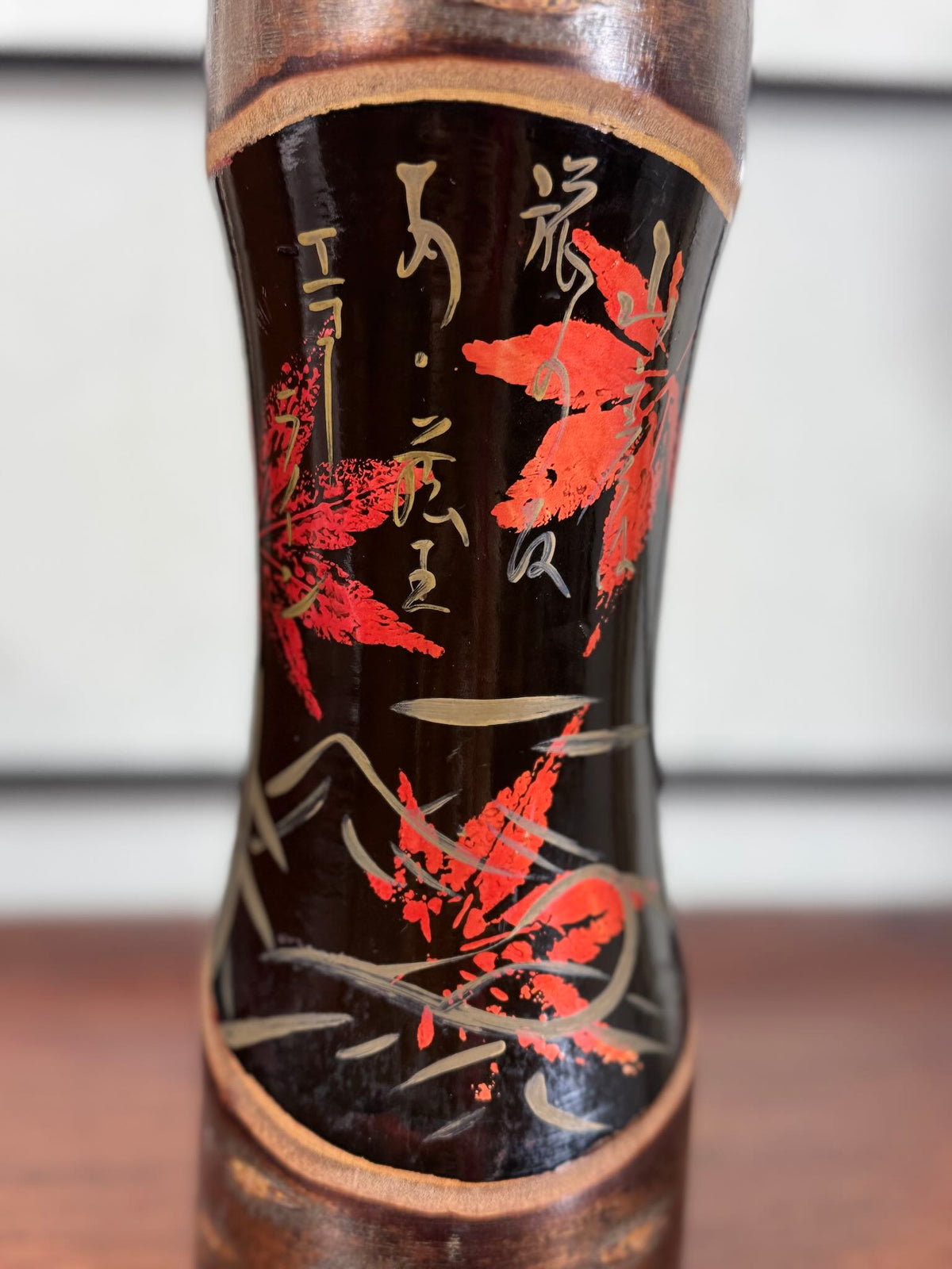 Kokeshi vintage Tatsurō Takahashi en bois et laque aux feuilles d’érable rouges, gros plan sur les calligraphies dorées
