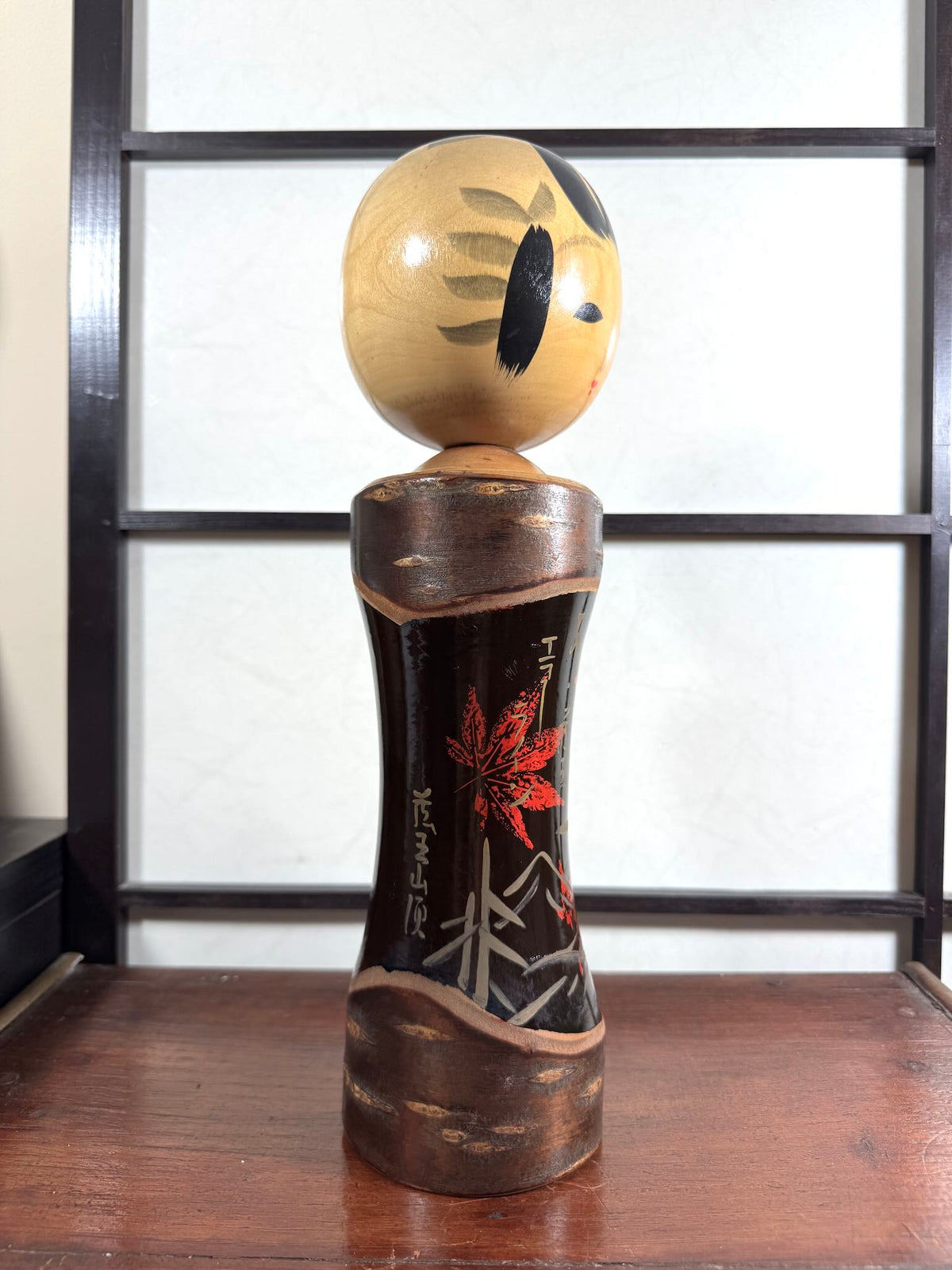 Kokeshi vintage Tatsurō Takahashi en bois et laque aux feuilles d’érable rouges, vu du profil droit