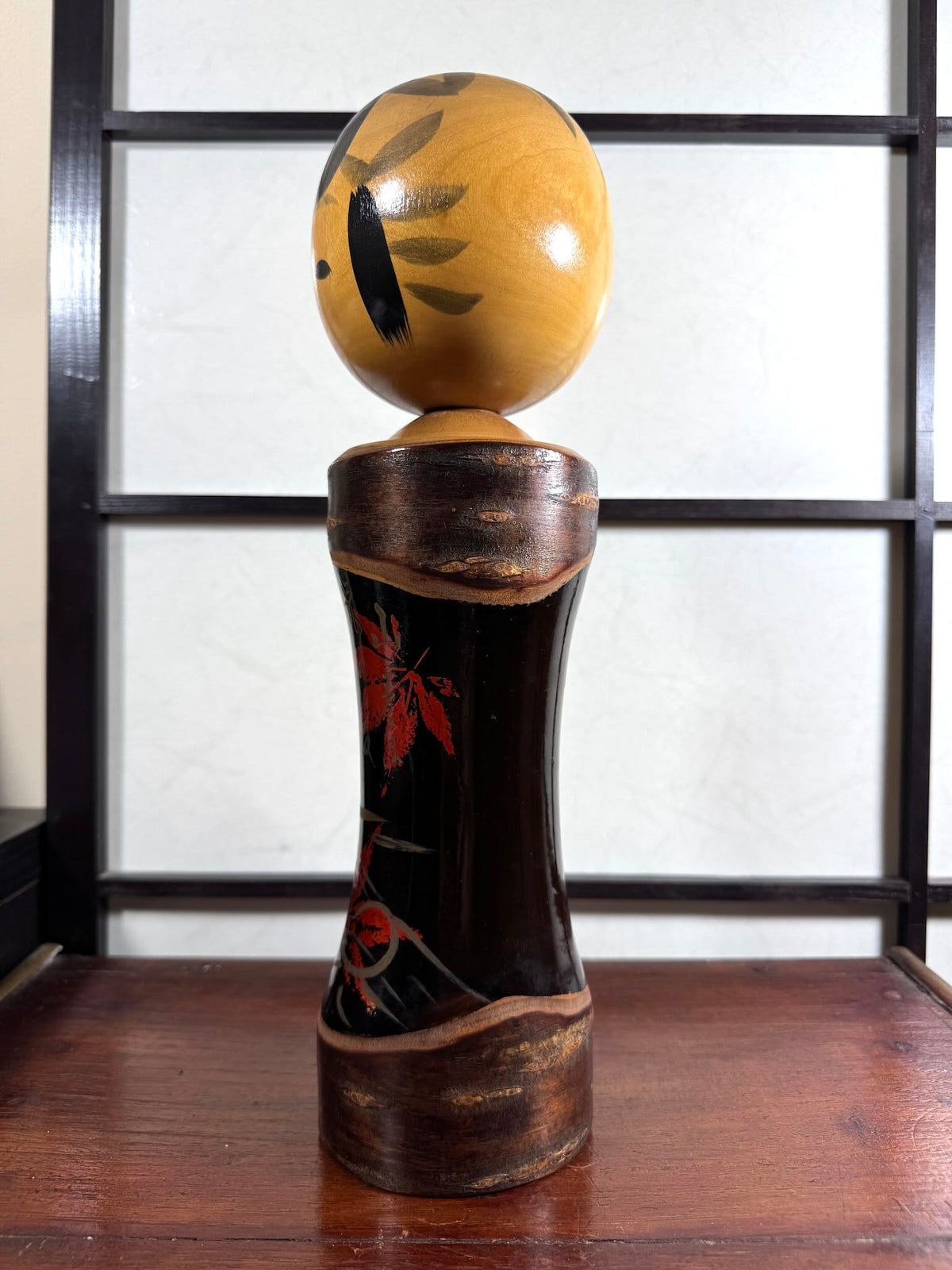 Kokeshi vintage Tatsurō Takahashi en bois et laque aux feuilles d’érable rouges, vu du profil gauche