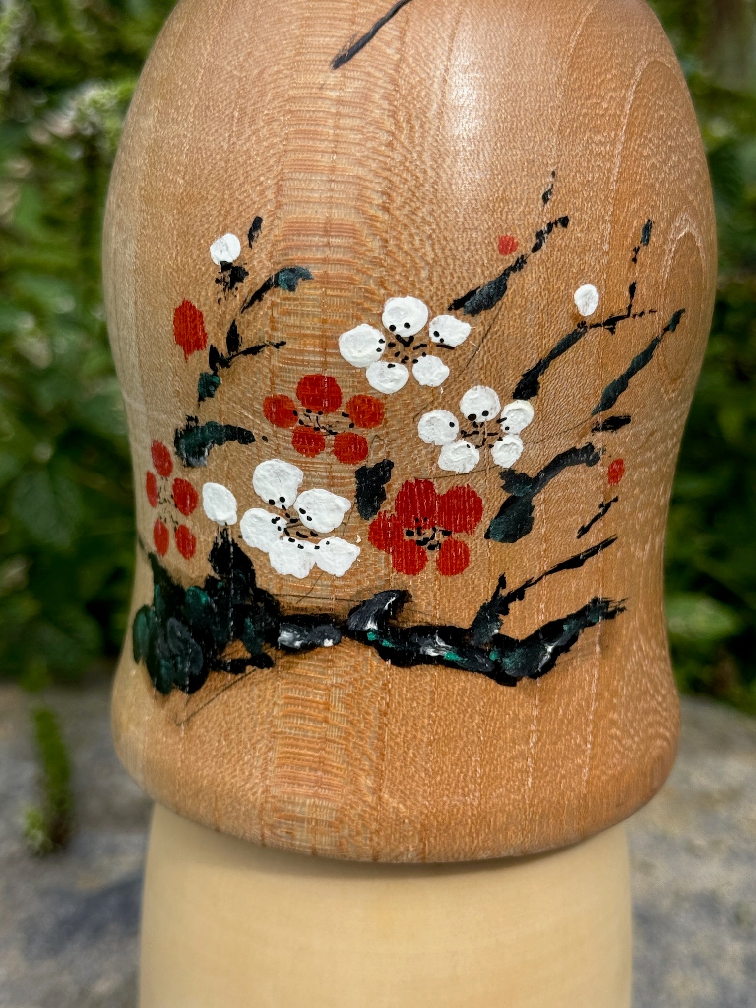 kokeshi poupée japonaise en bois de Yuho Ouchi, branche de prunier rouge et blanc en fleur, gros plan sur le motif