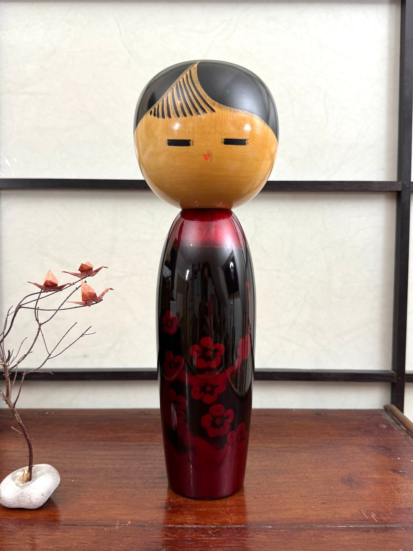 Kokeshi vintage de Sato Norio en laque noire et rouge avec branche de prunier en fleurs, vu de face
