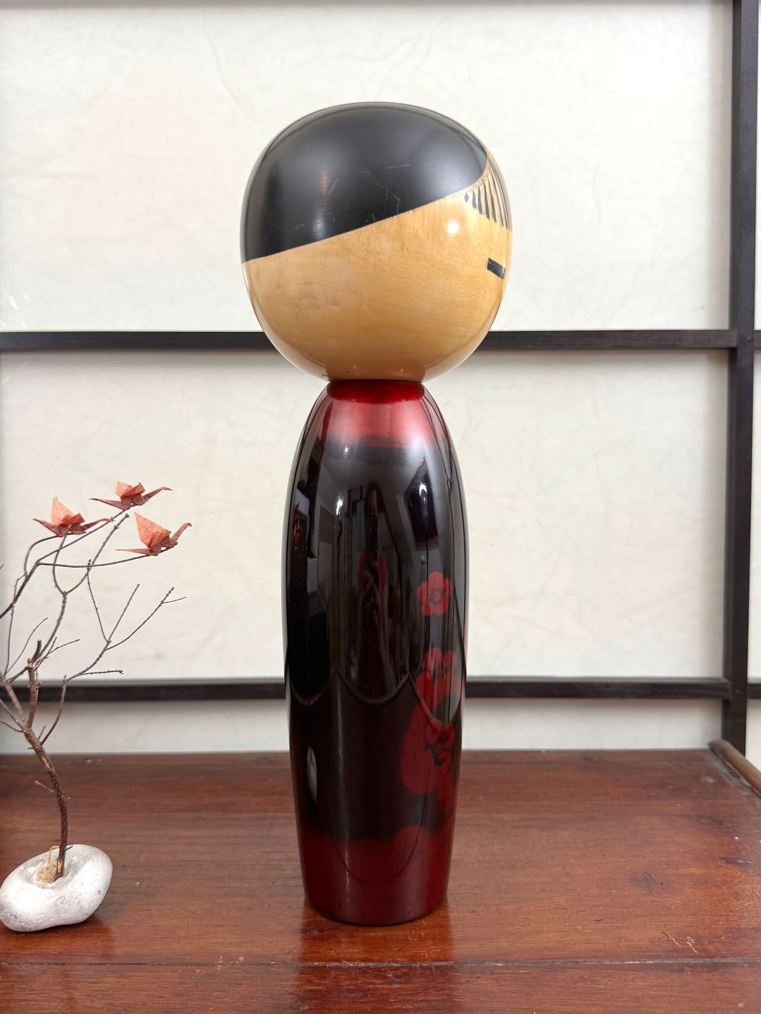 Kokeshi vintage de Sato Norio en laque noire et rouge avec branche de prunier en fleurs, vu du profil droit