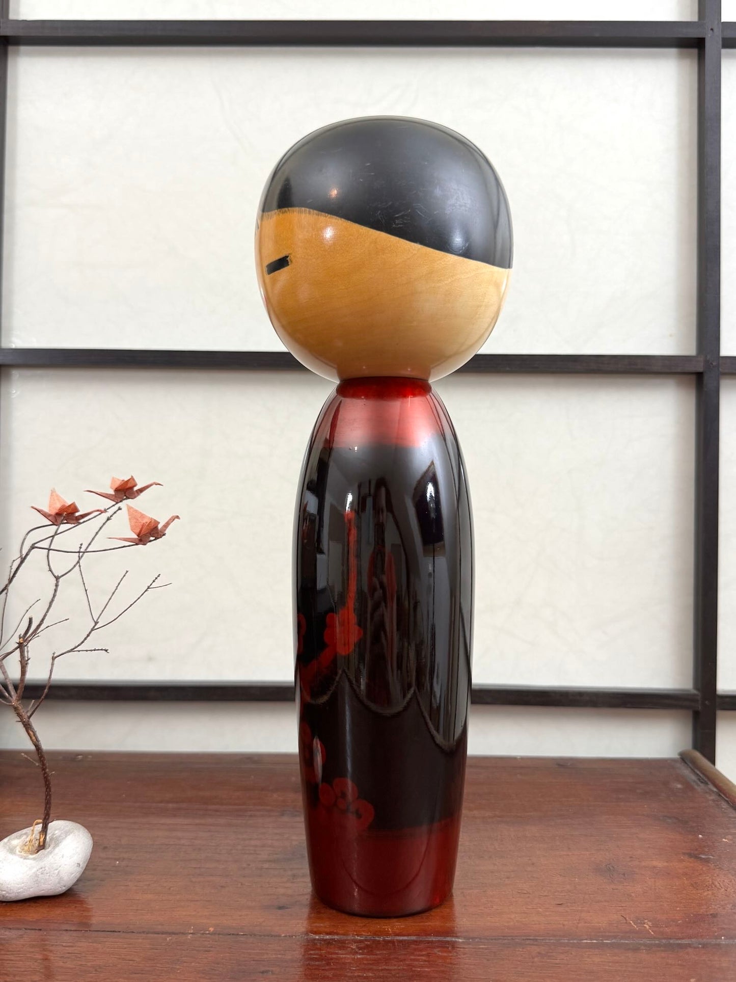 Kokeshi vintage de Sato Norio en laque noire et rouge avec branche de prunier en fleurs, vu du profil gauche