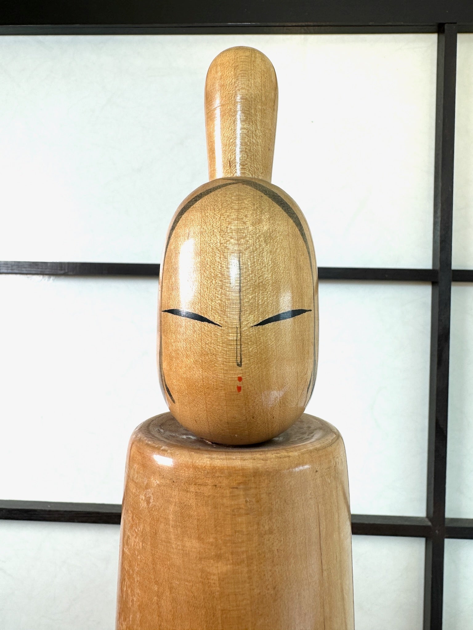 kokeshi poupée japonaise en bois de Shdo Shozan de grande taille (49,5cm), bois blond, lignes concentriques noires à la taille, coiffure en chignon haut, forme épurée, gros plan sur le visage