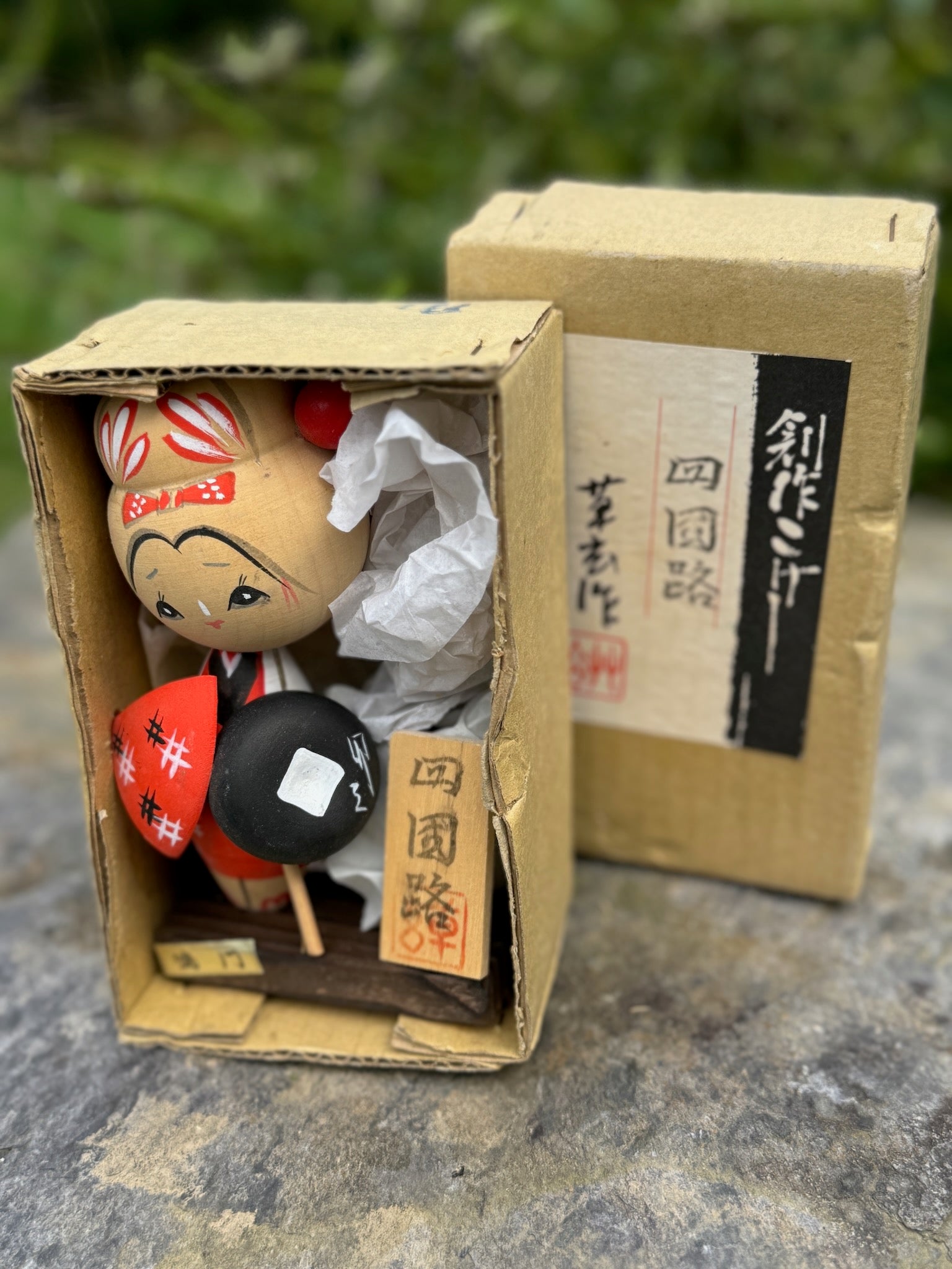 Kokeshi souvenir, poupée en bois japonaise, kimono orange et chapeau noir et blanc, pèlerinage de shikoku, épingle à cheveux rouge ronde, ruban peint et fleurs blanches sur chignon. Dans sa boîte.