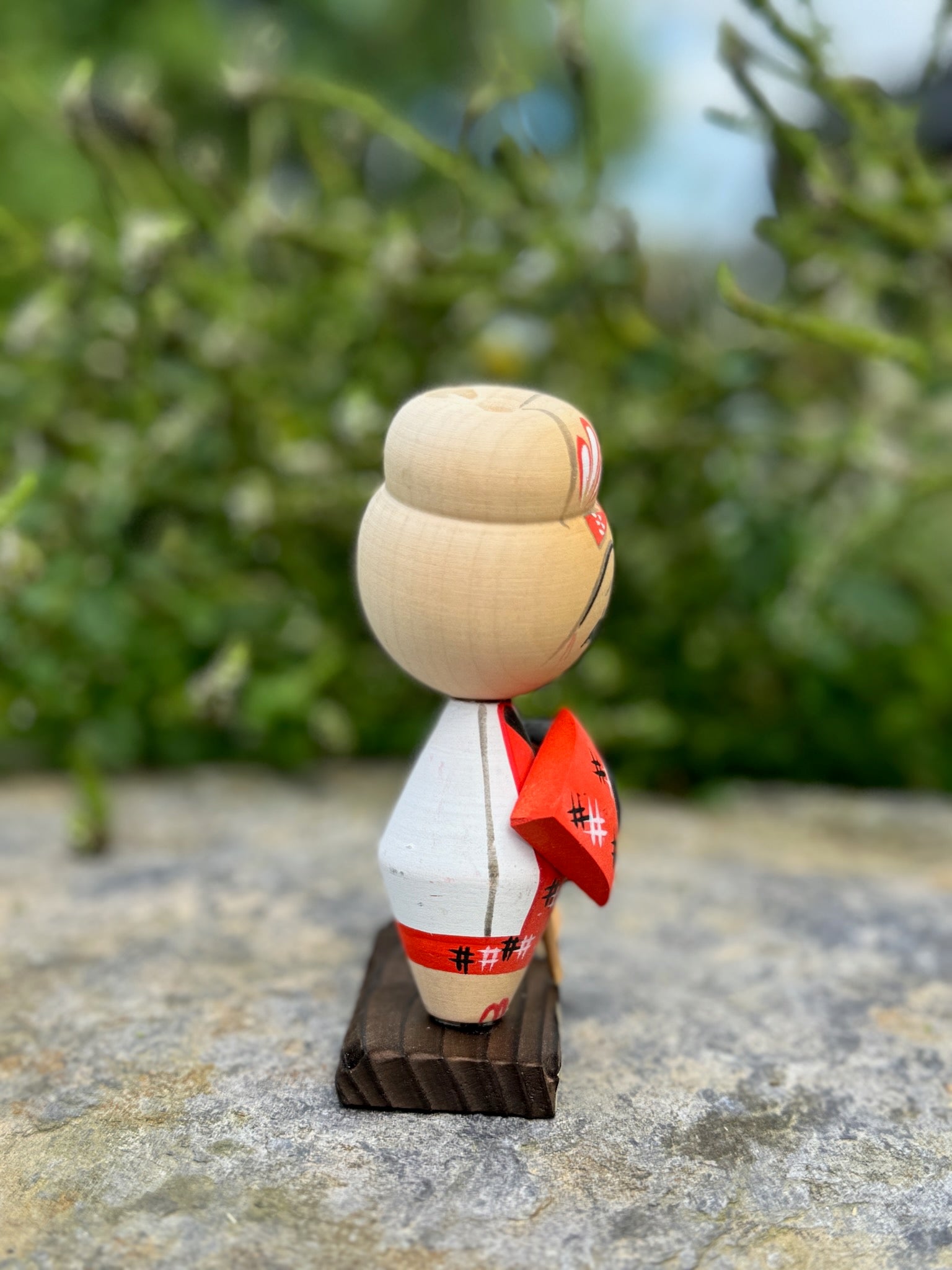 Kokeshi souvenir, poupée en bois japonaise, kimono orange et chapeau noir et blanc, pèlerinage de shikoku, Poupée de profil gauche kimono orange et veste blanche. 