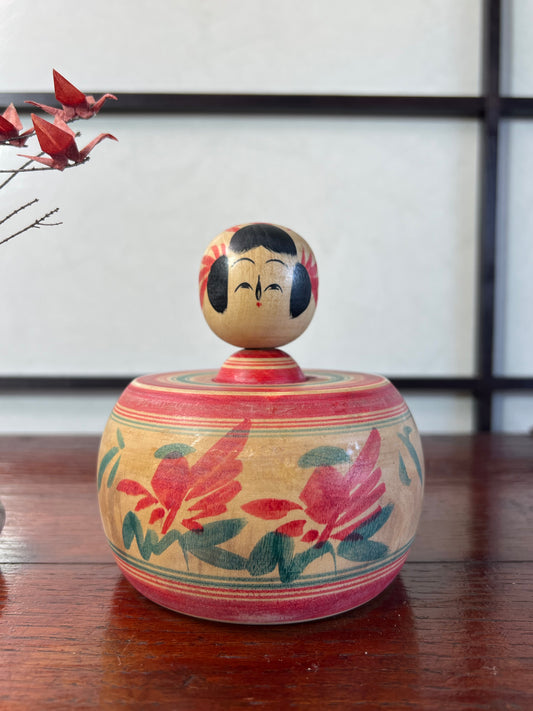 Kokeshi de style Sakunami de Hiraga Tadashi   | Forme Ejiko, bébé dans son panier Décor pivoine rayure rouges et vertes