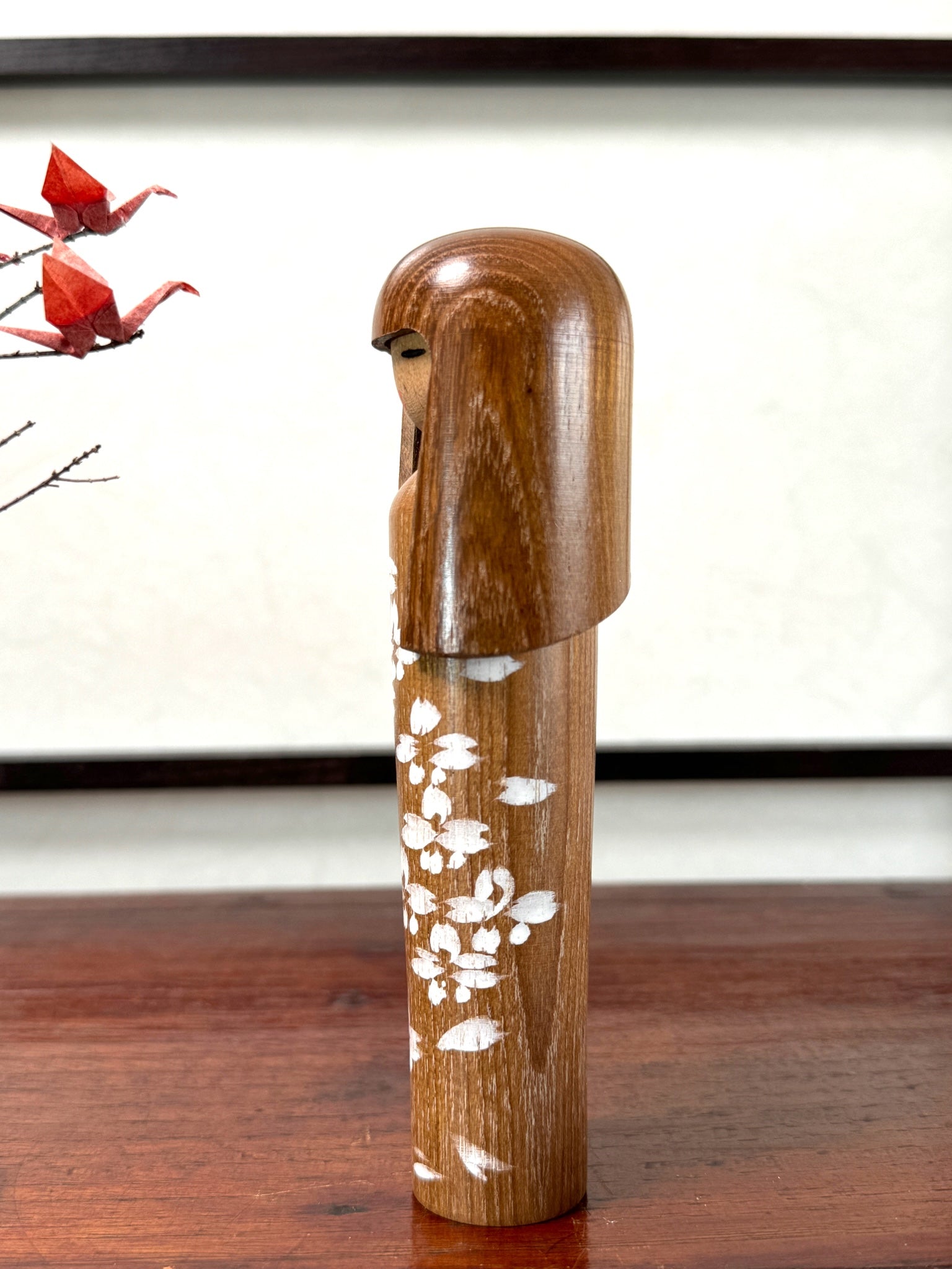 kokeshi, poupée japonaise en bois décoré de fleurs blanches, profil gauche