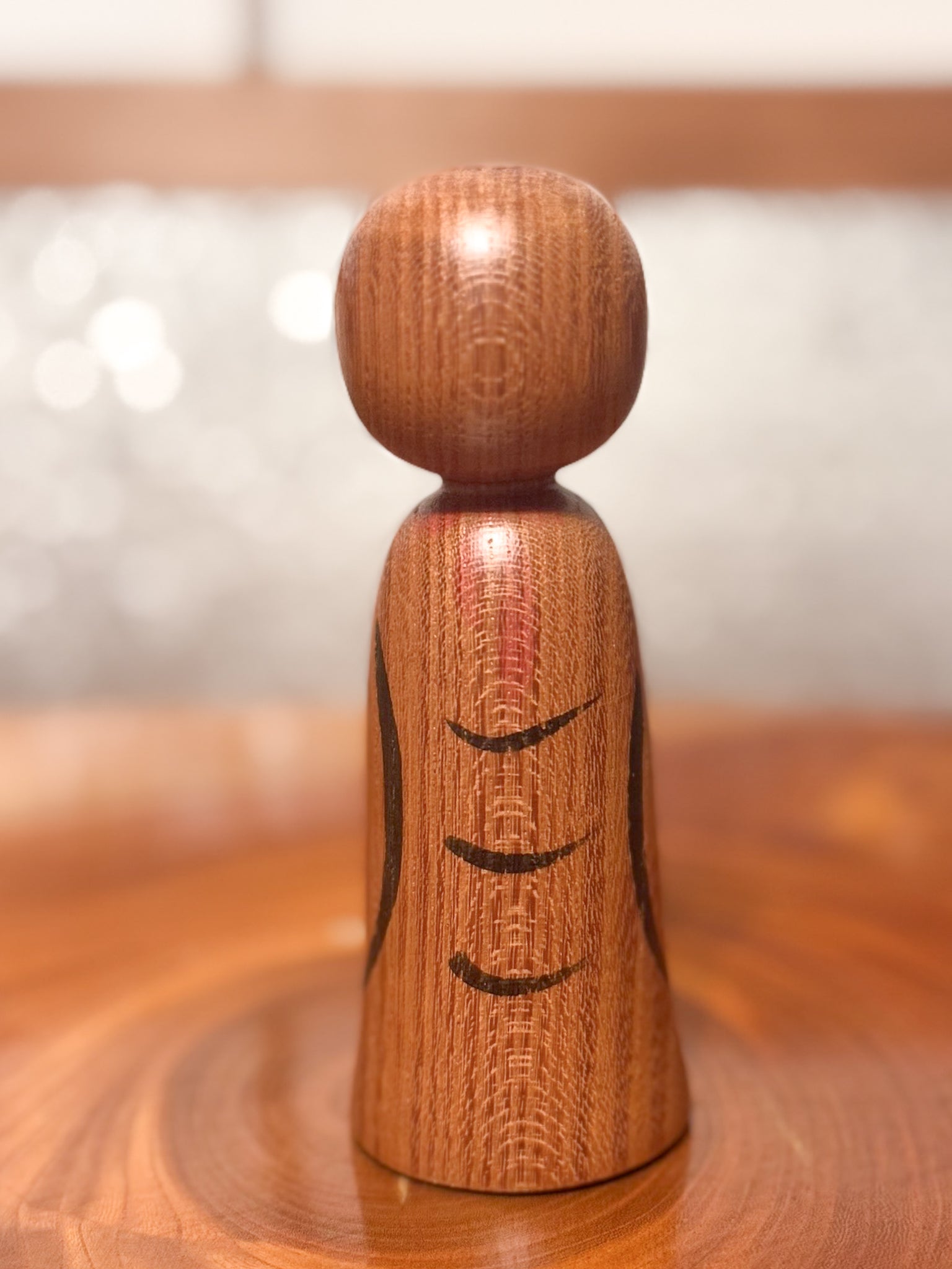 kokeshi représentant un jizo mains jointes en prière, vu de dos