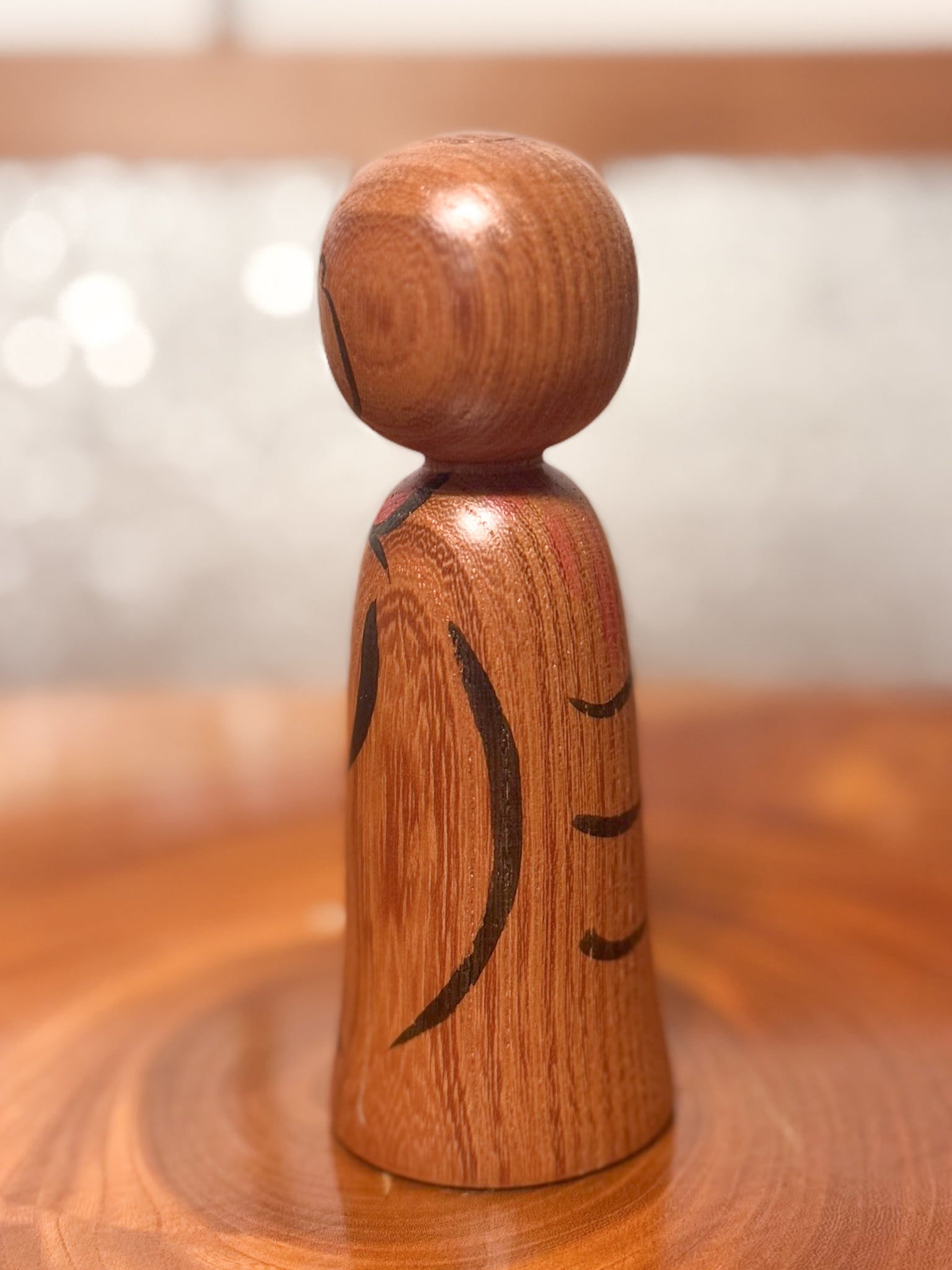 kokeshi représentant un jizo mains jointes en prière, vu de 3/4 gauche