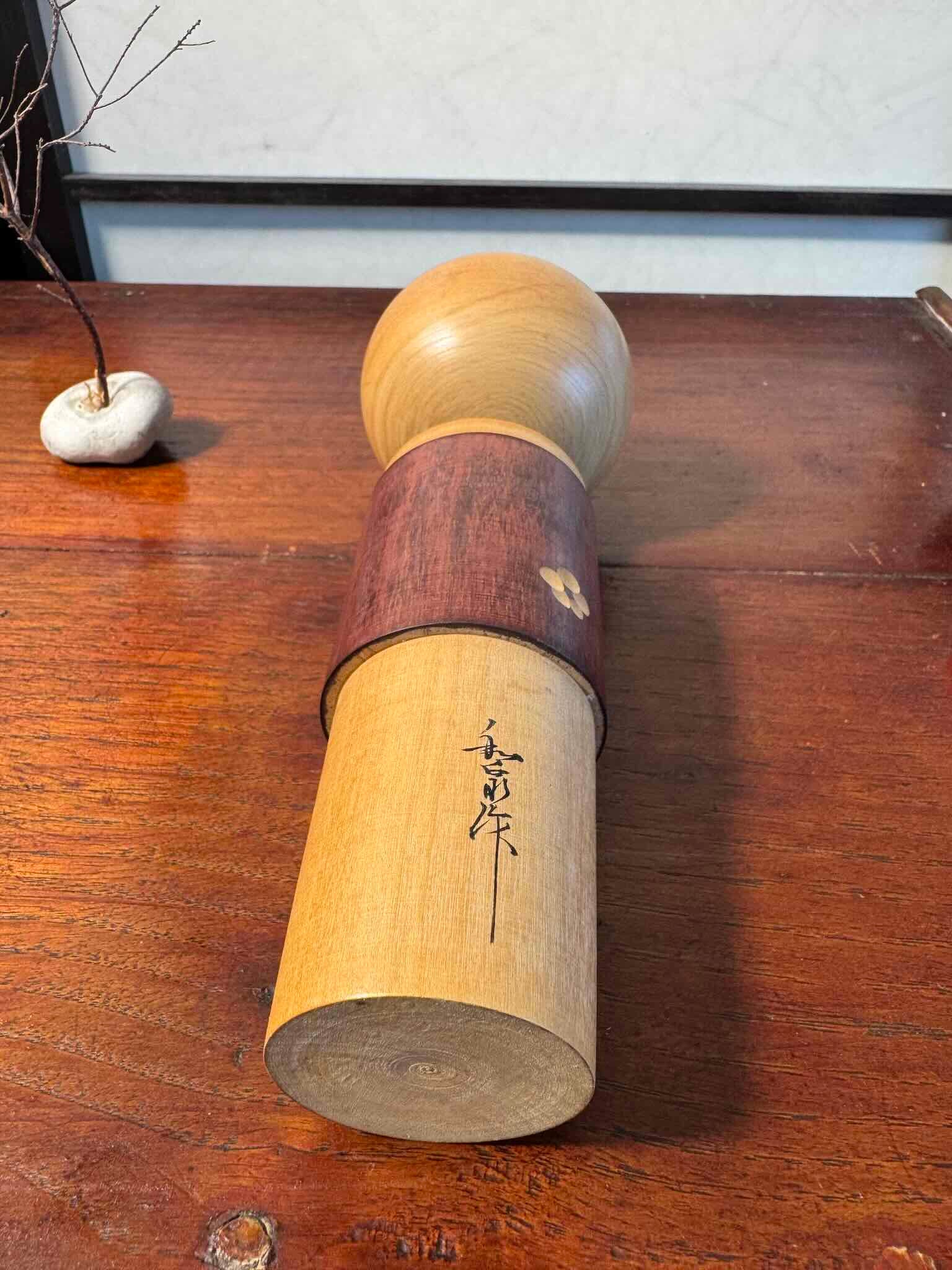 Kokeshi créative japonaise ancienne en bois naturel avec motifs floraux, la signature de l'artisan