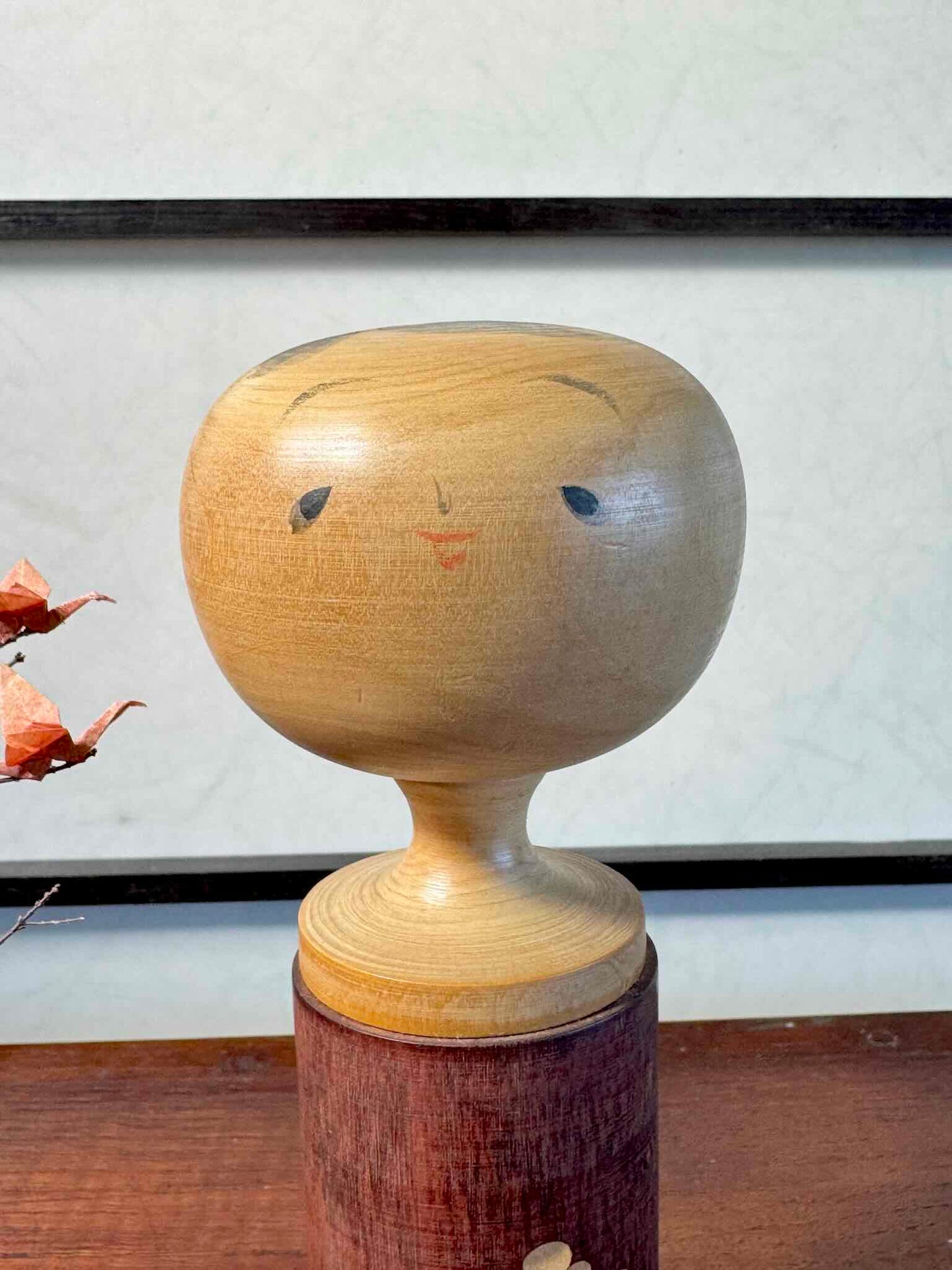 Kokeshi créative japonaise ancienne en bois naturel avec motifs floraux, gros plan du visage soutriant
