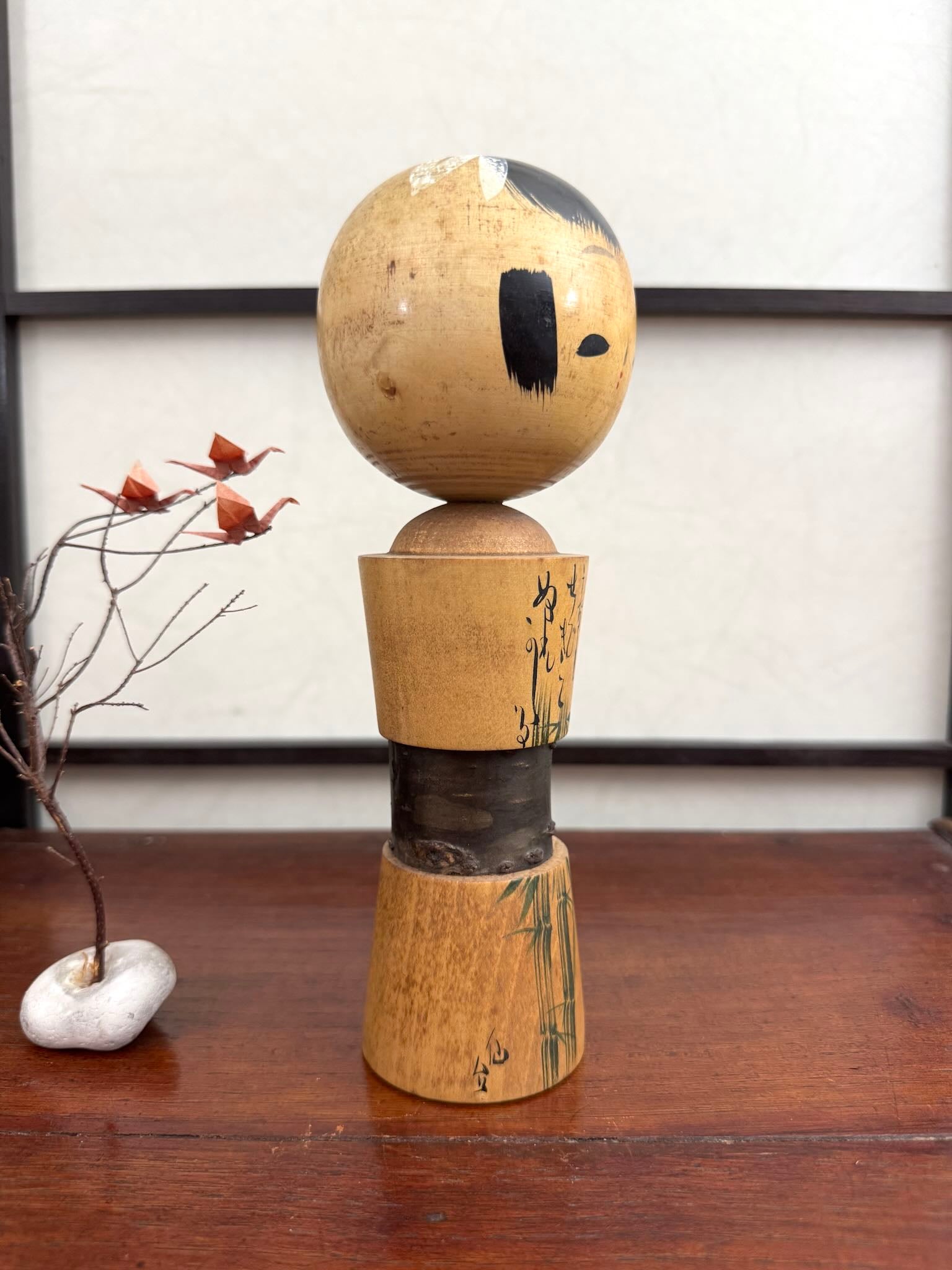 Kokeshi avec ecorce de cerisier, bambous et  calligraphie, vue profil 