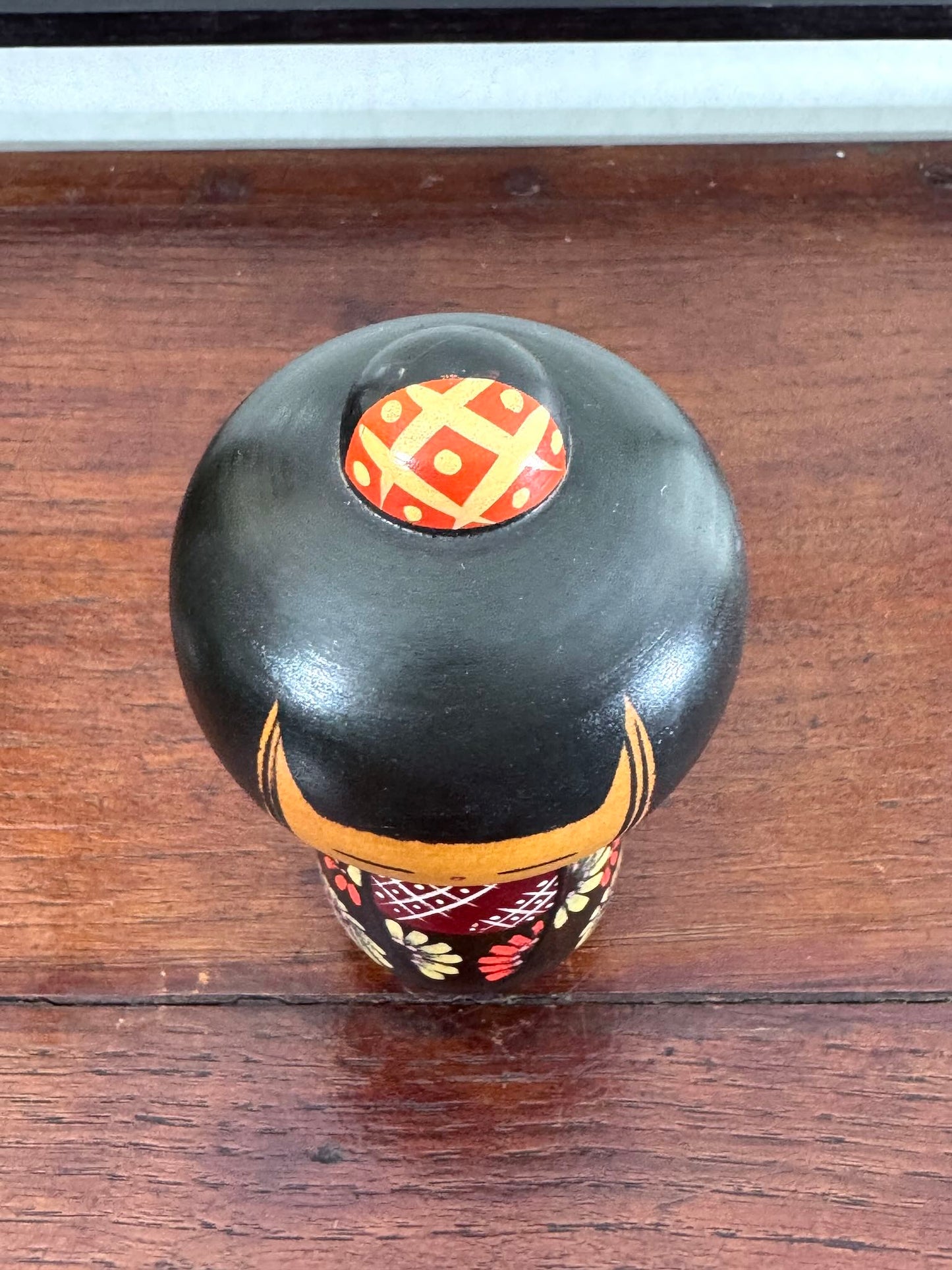 Poupée Kokeshi en bois, chignon et kimono et fleurs peintes, vue dessus