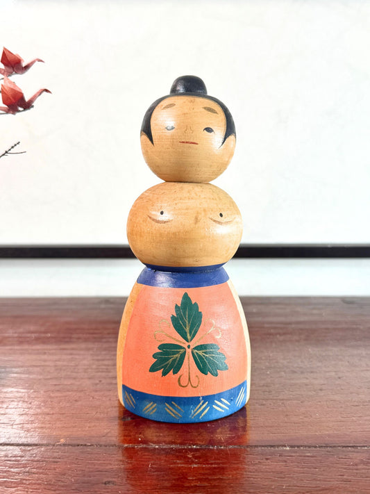 Kokeshi japonaise vintage représentant un sumo, en bois peint avec tablier au motif végétal stylisé