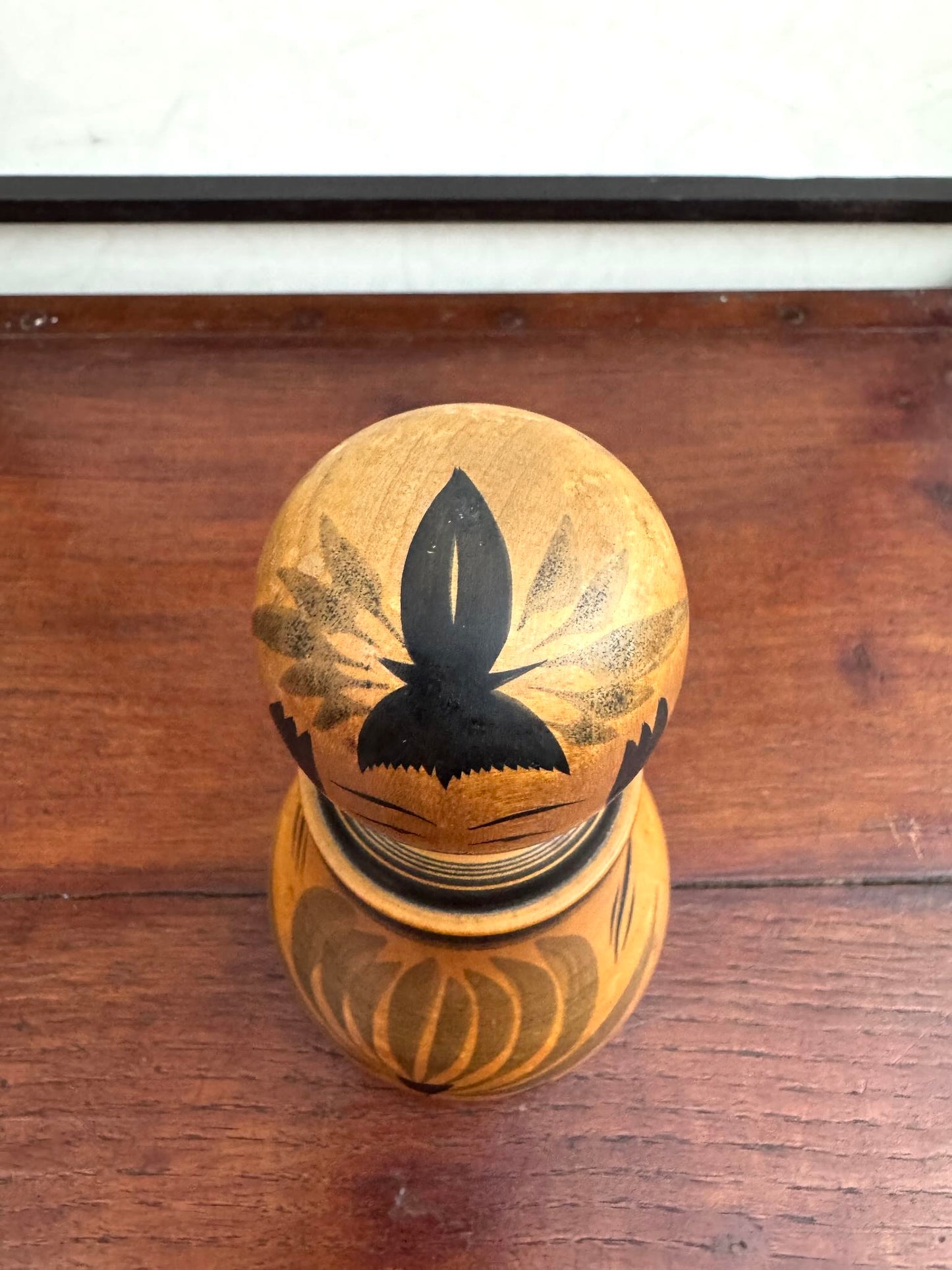 Poupée Japonaise Kokeshi nemariko de Sato Yoshihiro, avec un grand chrysanthème noir peint à la main, vu du dessus