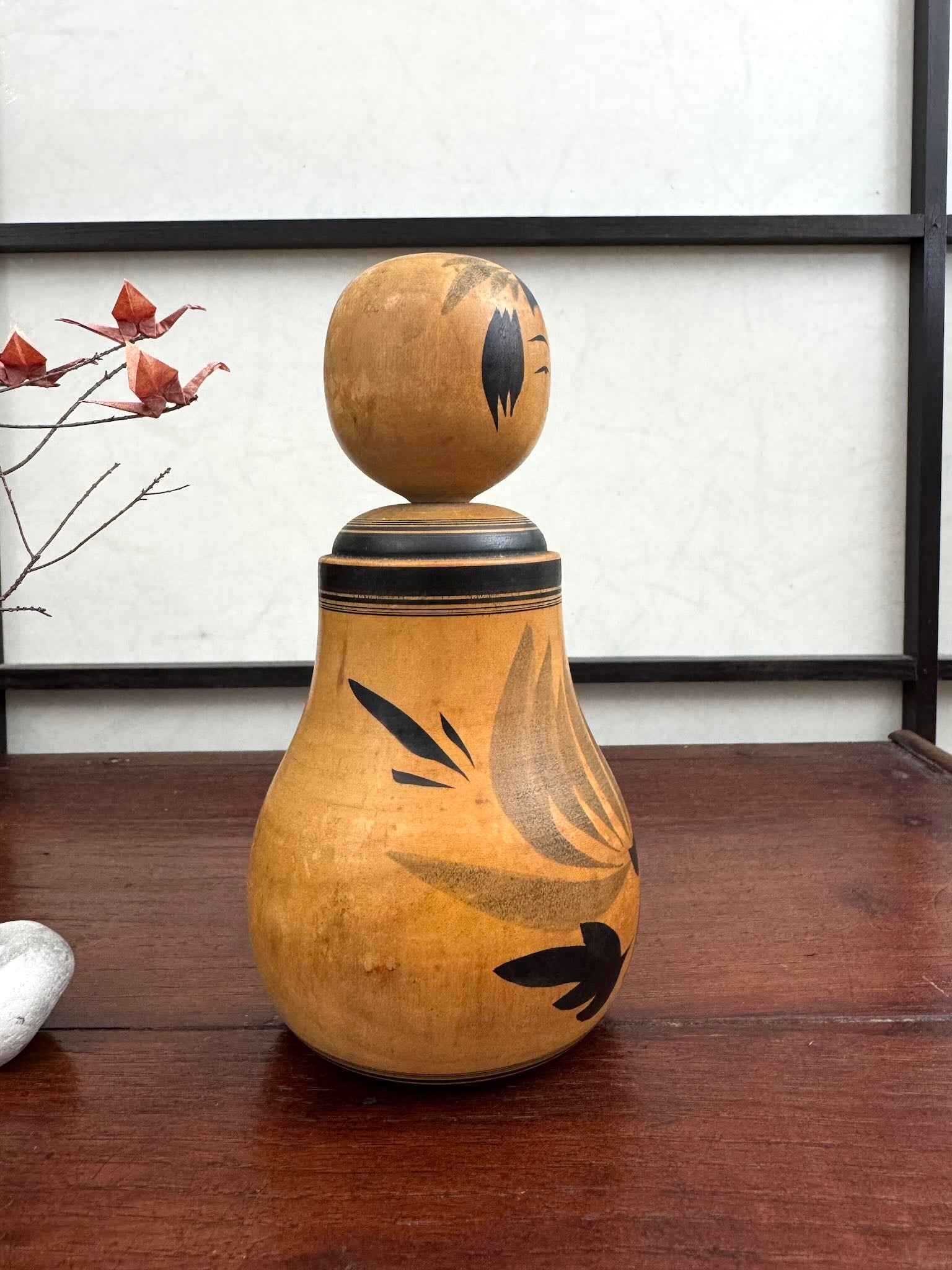 Poupée Japonaise Kokeshi nemariko de Sato Yoshihiro, avec un grand chrysanthème noir peint à la main, vu du profil droit