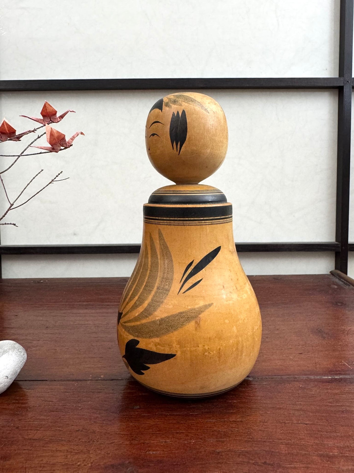 Poupée Japonaise Kokeshi nemariko de Sato Yoshihiro, avec un grand chrysanthème noir peint à la main, vu du profil gauche