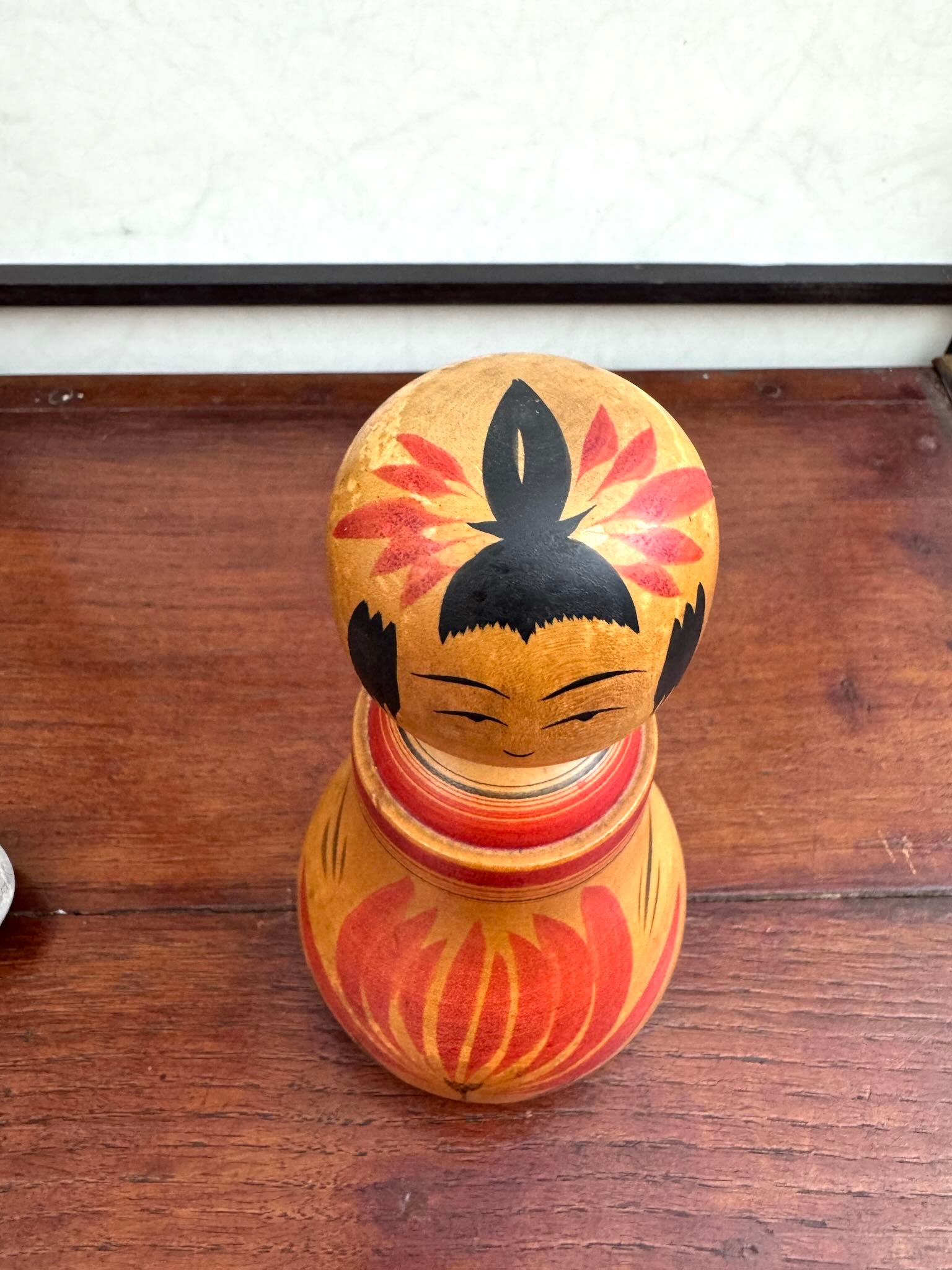Poupée Japonaise Kokeshi nemariko de Sato Yoshihiro, avec un grand chrysanthème rouge peint à la main, vue dessus